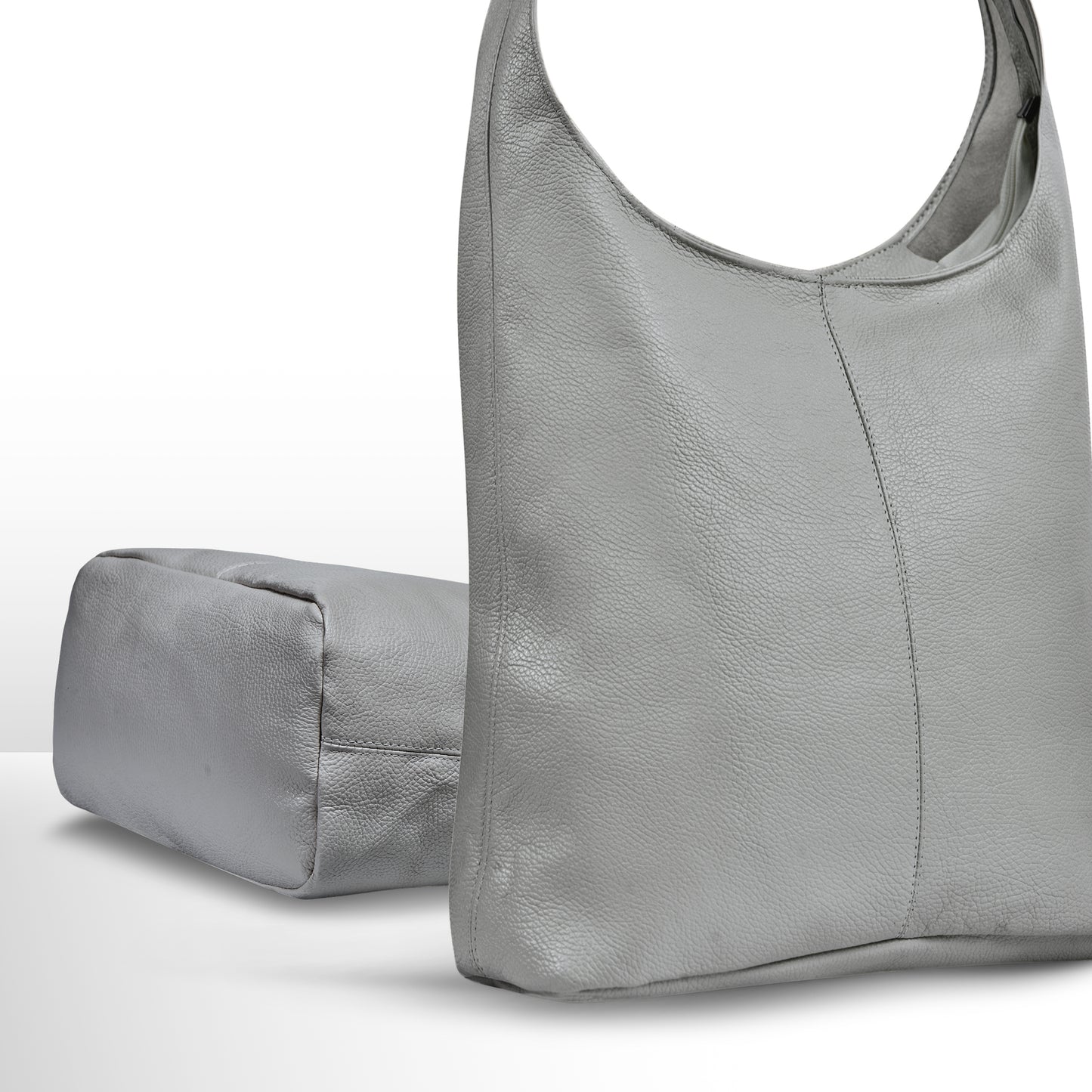 Gray leather handbag with a smooth texture alongside a matching soft, rectangular pouch.