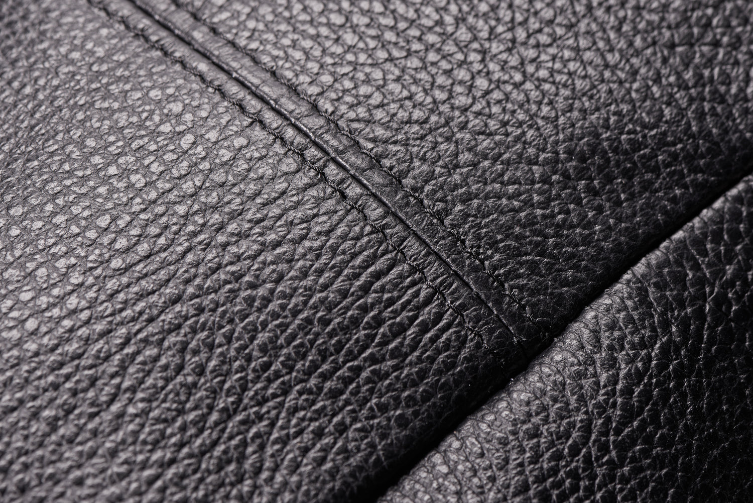 Close-up of full-grain Italian leather texture – beige color, natural grain visible.