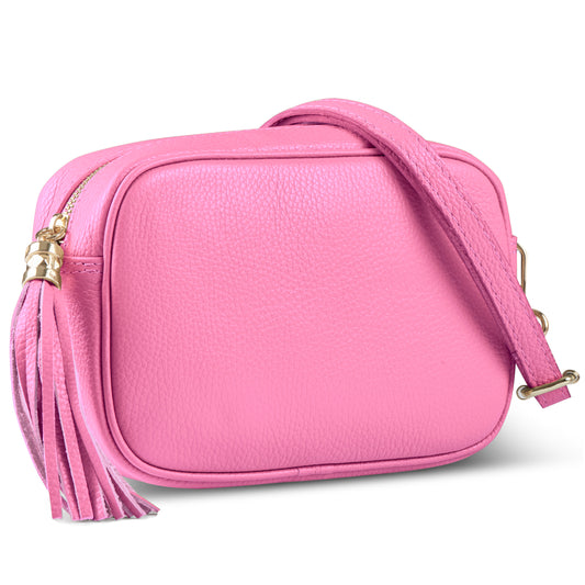A small rectangular pink women’s crossbody bag, handcrafted in Italy from pebbled leather with a matching adjustable strap, tassel zipper detail, and gold hardware.