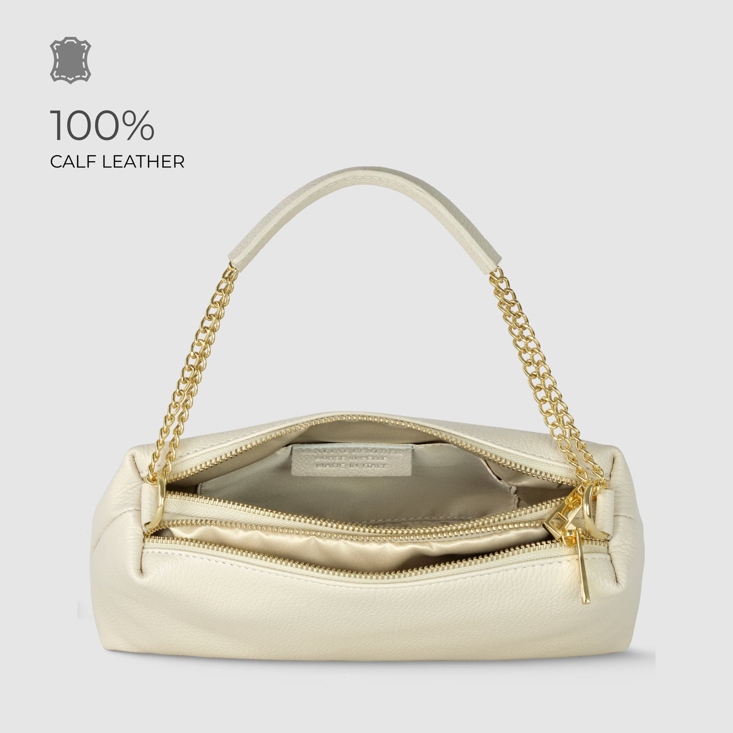A cream-colored calf leather handbag with a gold chain handle and zipper. This luxury shoulder bag is open, revealing a beige interior and inner pocket. Text reads 100% CALF LEATHER against a light gray background.