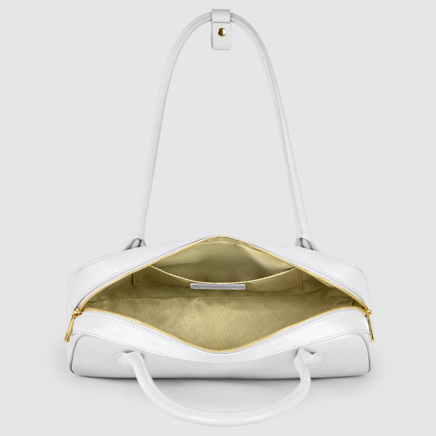 A white Italian leather bag with gold zipper hardware is open to reveal a beige interior lining. The bag has two handles and is displayed on a light gray background.