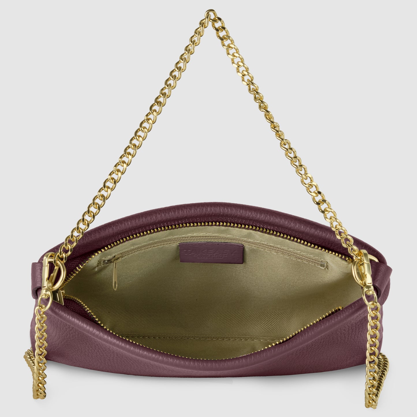 A small, textured purple Italian leather crossbody purse with a gold chain strap. The bag is open, showing a light beige interior with a zippered pocket and smooth lining—an elegant handcrafted handbag for any occasion.