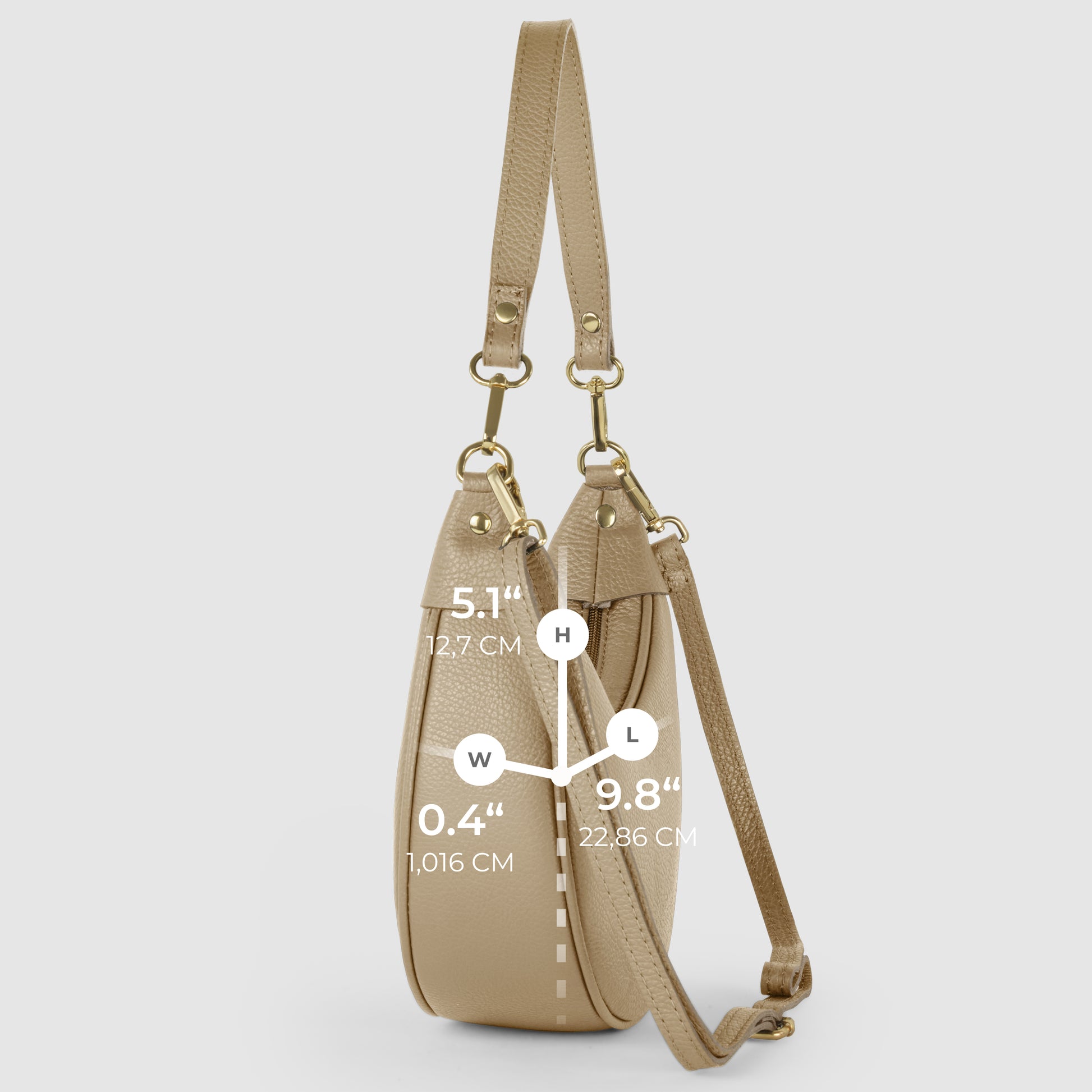A crescent-shaped handbag in beige Italian calf leather is shown from the side on a light background, with white measurement labels for height (5.1/12.7 cm), width (0.4/1.016 cm), and length (9.8/22.36 cm).