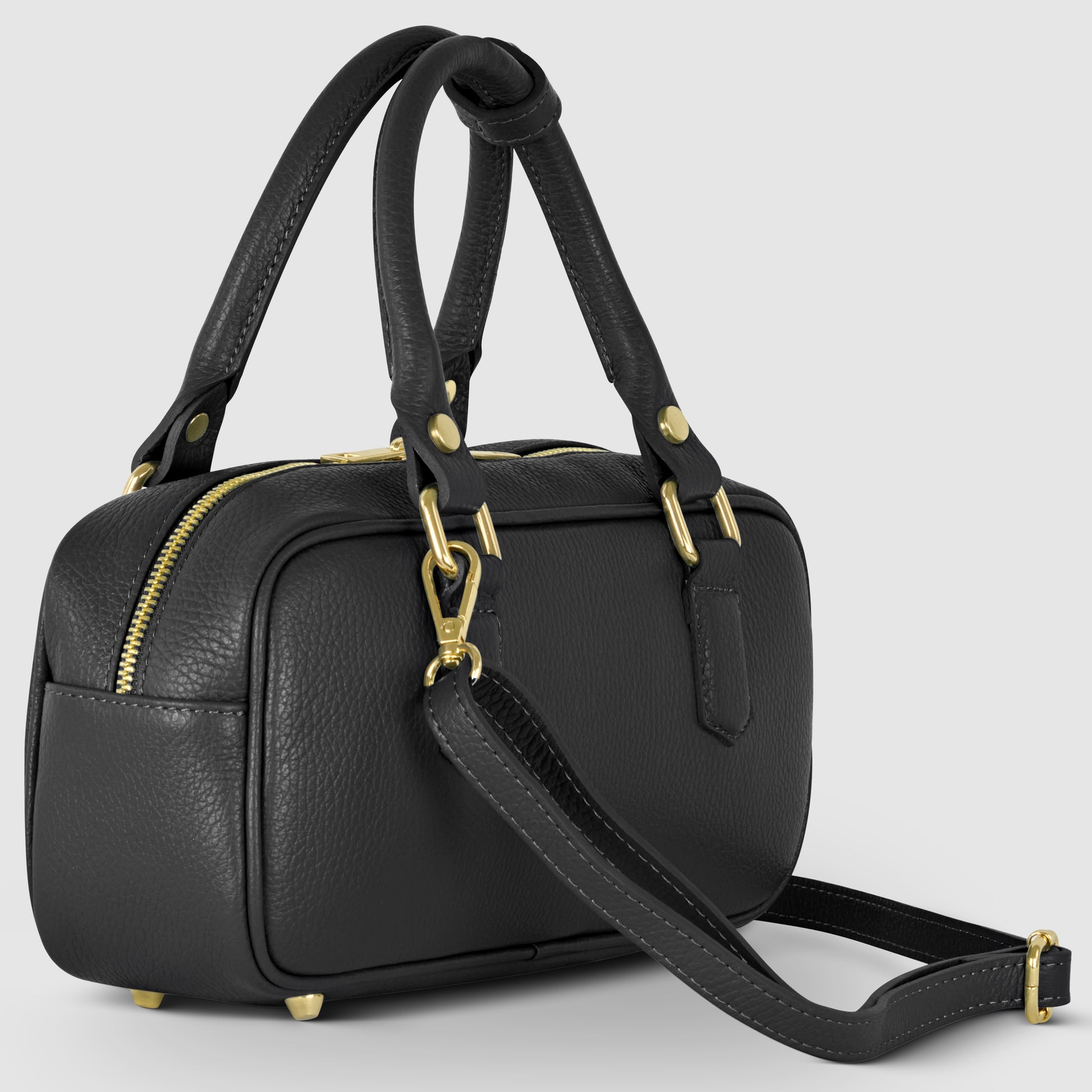 A small black pebbled leather bag with gold hardware, double top handles, and a detachable shoulder strap, shown against a light gray background. The Italian leather handbag features a textured finish and a zippered closure.