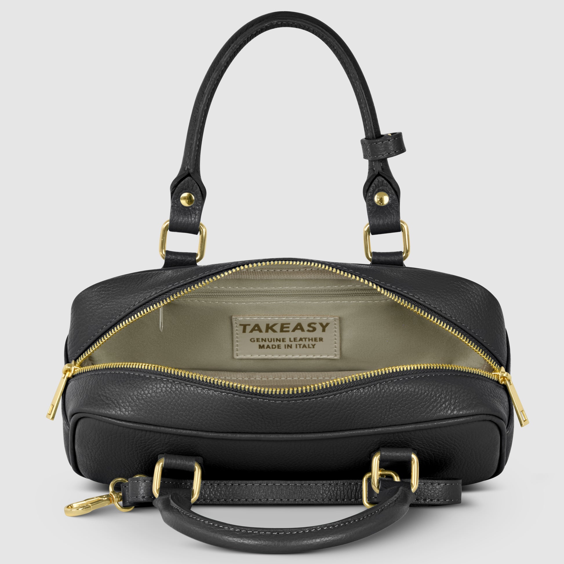 A minimalist Italian leather handbag with gold hardware is shown open, revealing a beige interior and a TAKEASY GENUINE LEATHER MADE IN ITALY label. The bag has two handles and a zippered closure.