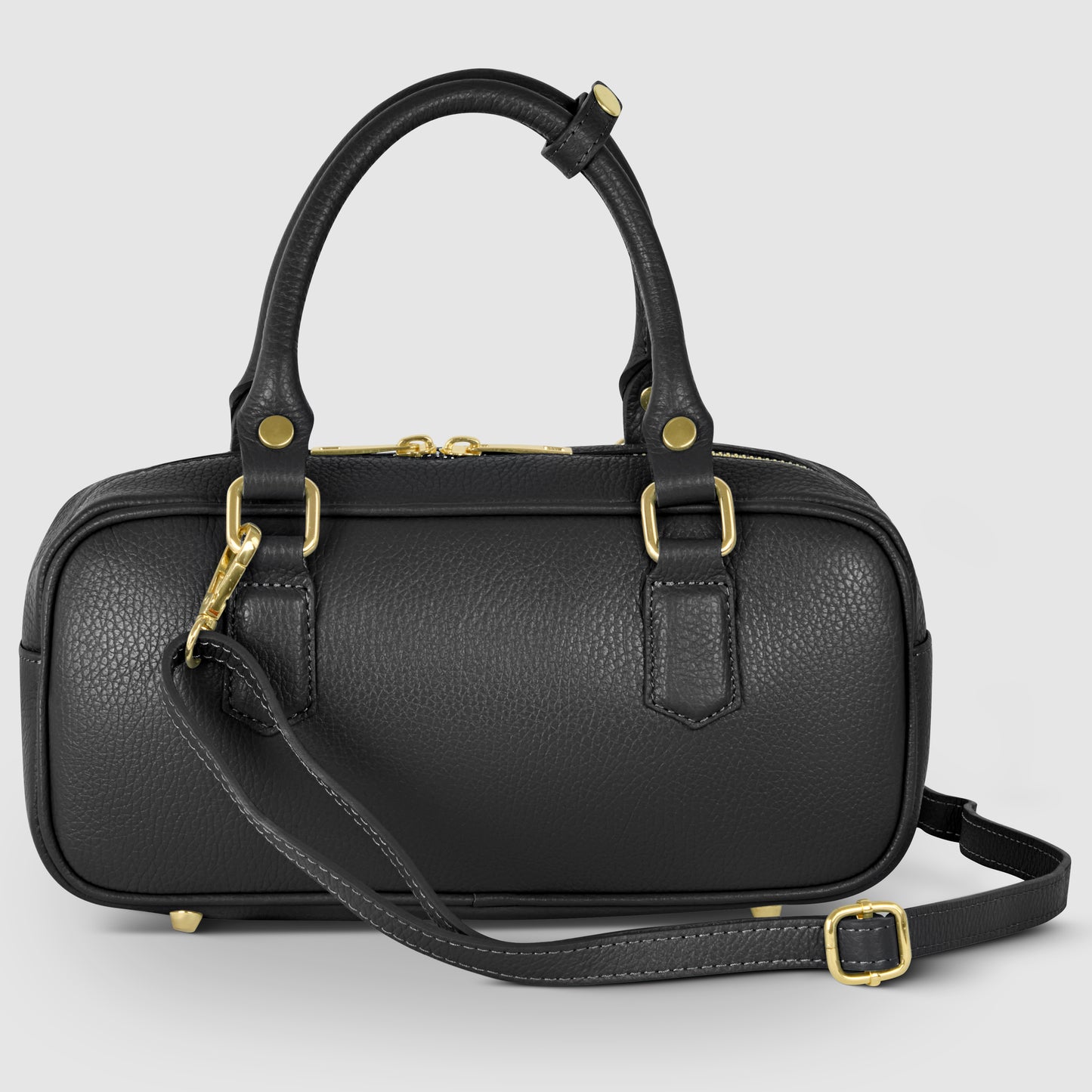 A small black pebbled leather bag with gold hardware, two short handles, and a detachable adjustable shoulder strap, displayed against a light gray background.