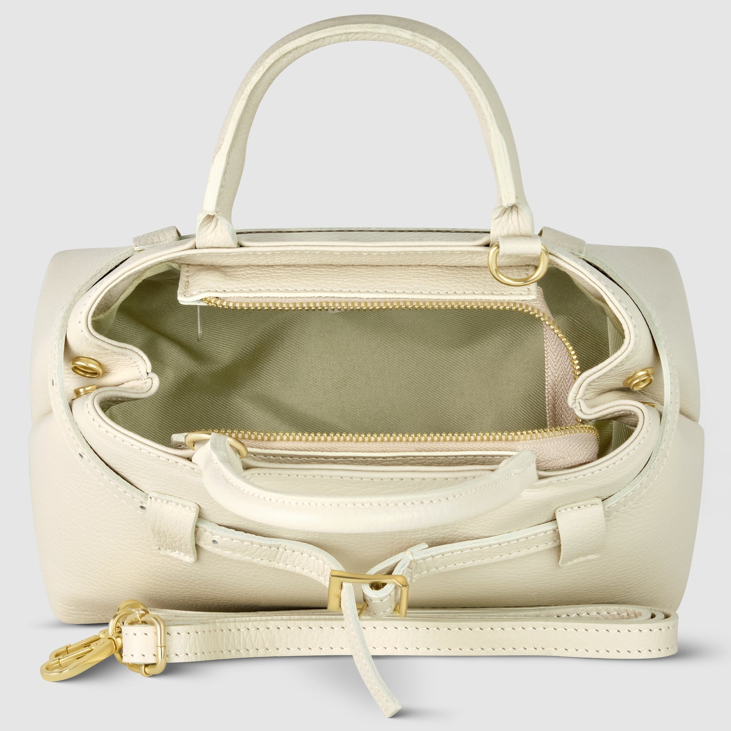 A cream-colored Italian leather handbag with gold-toned hardware, shown open to reveal a beige fabric-lined interior, an inner zippered pocket, two handles, and a detachable shoulder strap placed in front.