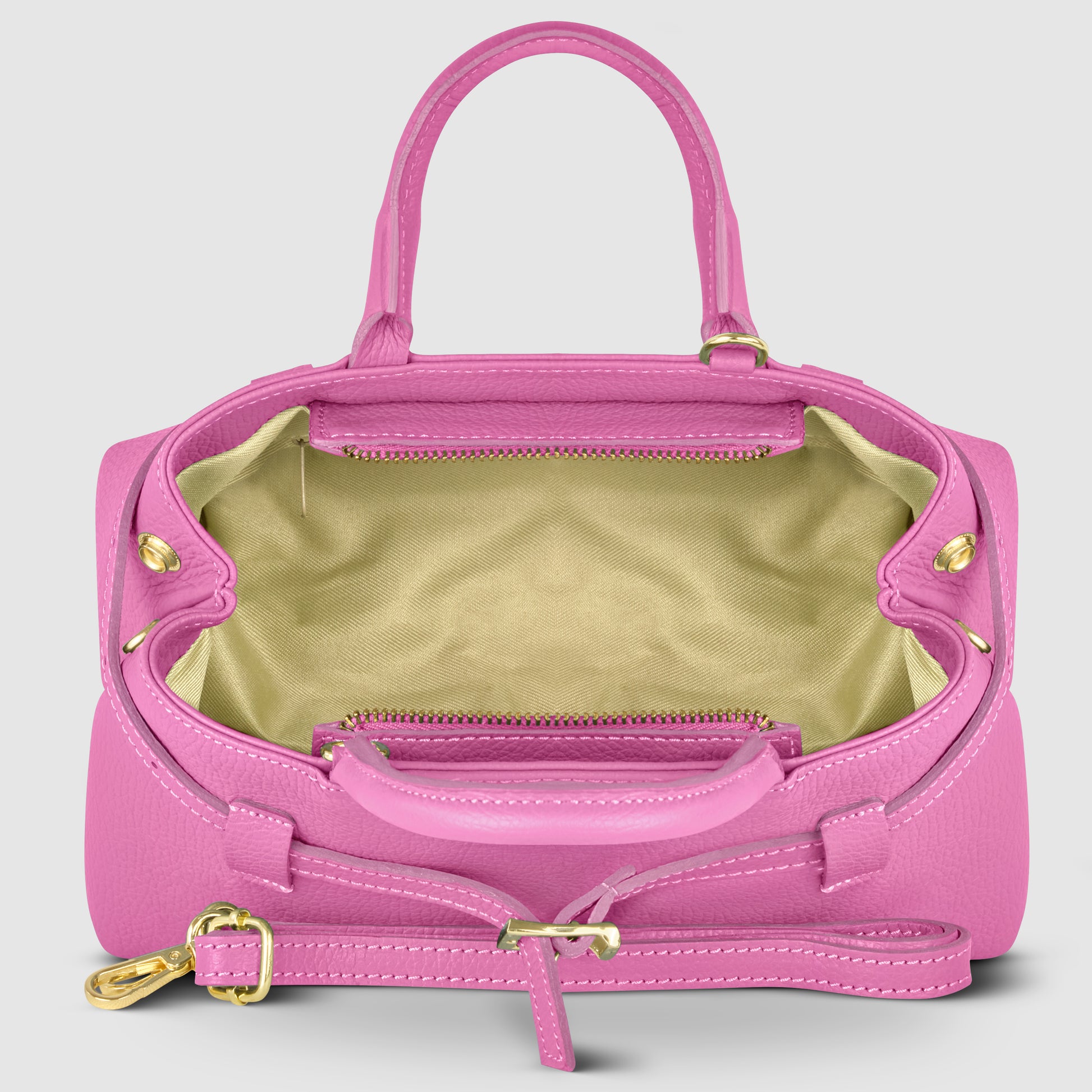 A pink Italian leather handbag with gold hardware, handmade in Italy. Shown open to reveal a spacious, light beige interior and a zippered pocket inside. The bag has two handles and a detachable strap.