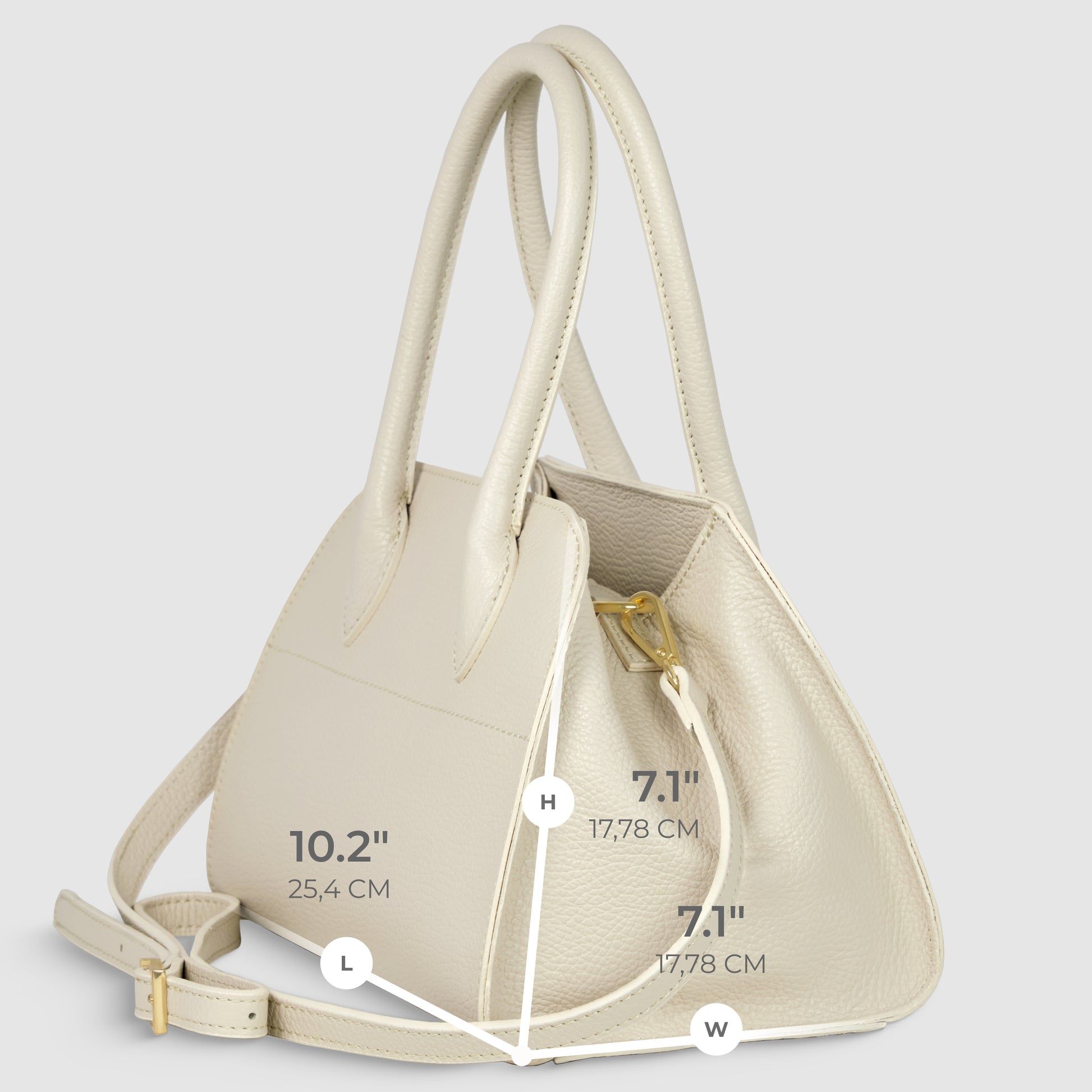 A cream-colored Italian leather handbag, handcrafted in Italy, with two handles and a shoulder strap is shown at an angle. Dimensions are labeled: length 10.2 (25.4 cm), height 7.1 (17.78 cm), and width 7.1 (17.78 cm).