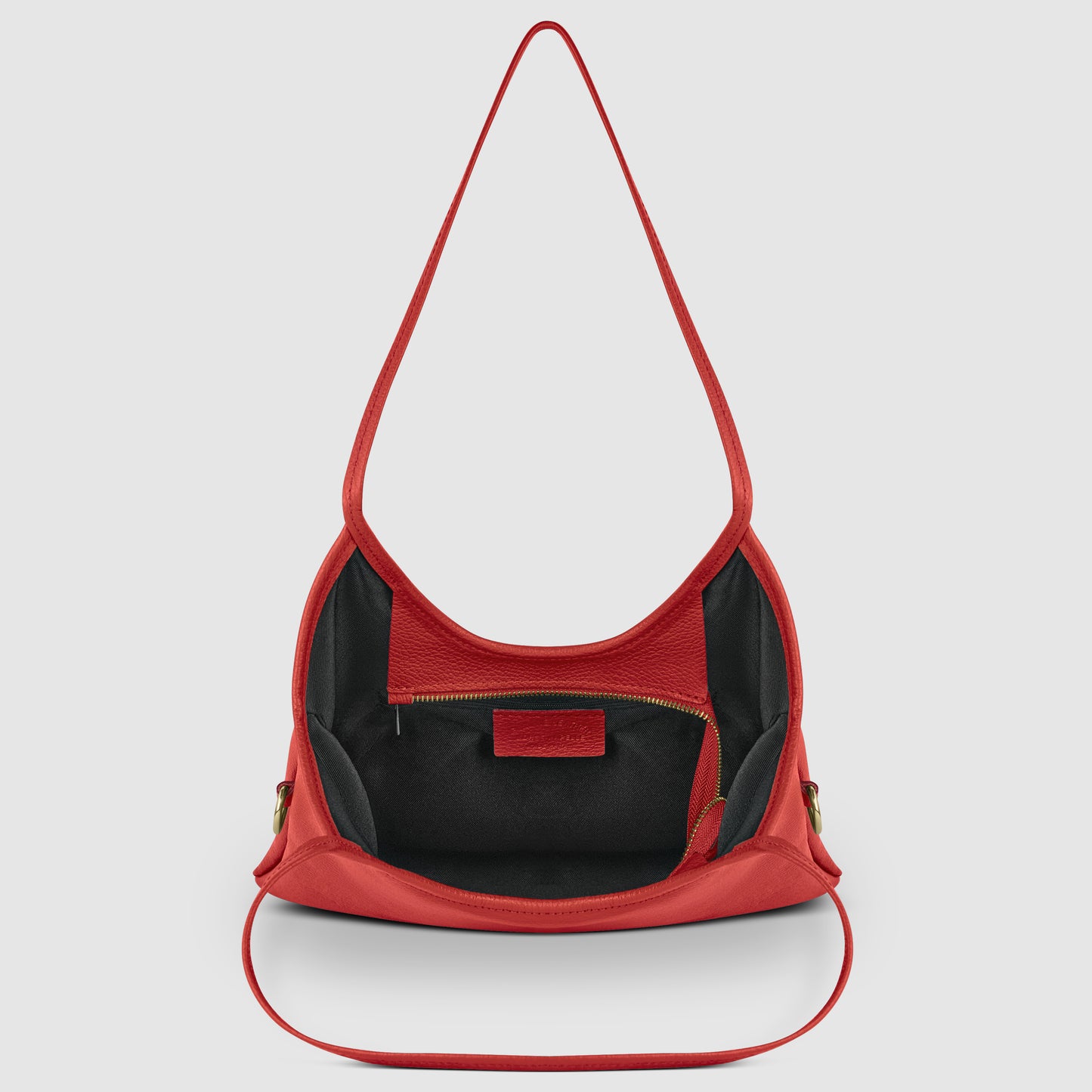 A red Italian leather shoulder bag with a single strap, shown open to reveal a black interior with a zippered pocket and a red leather patch, highlighting fine Florentine craftsmanship.
