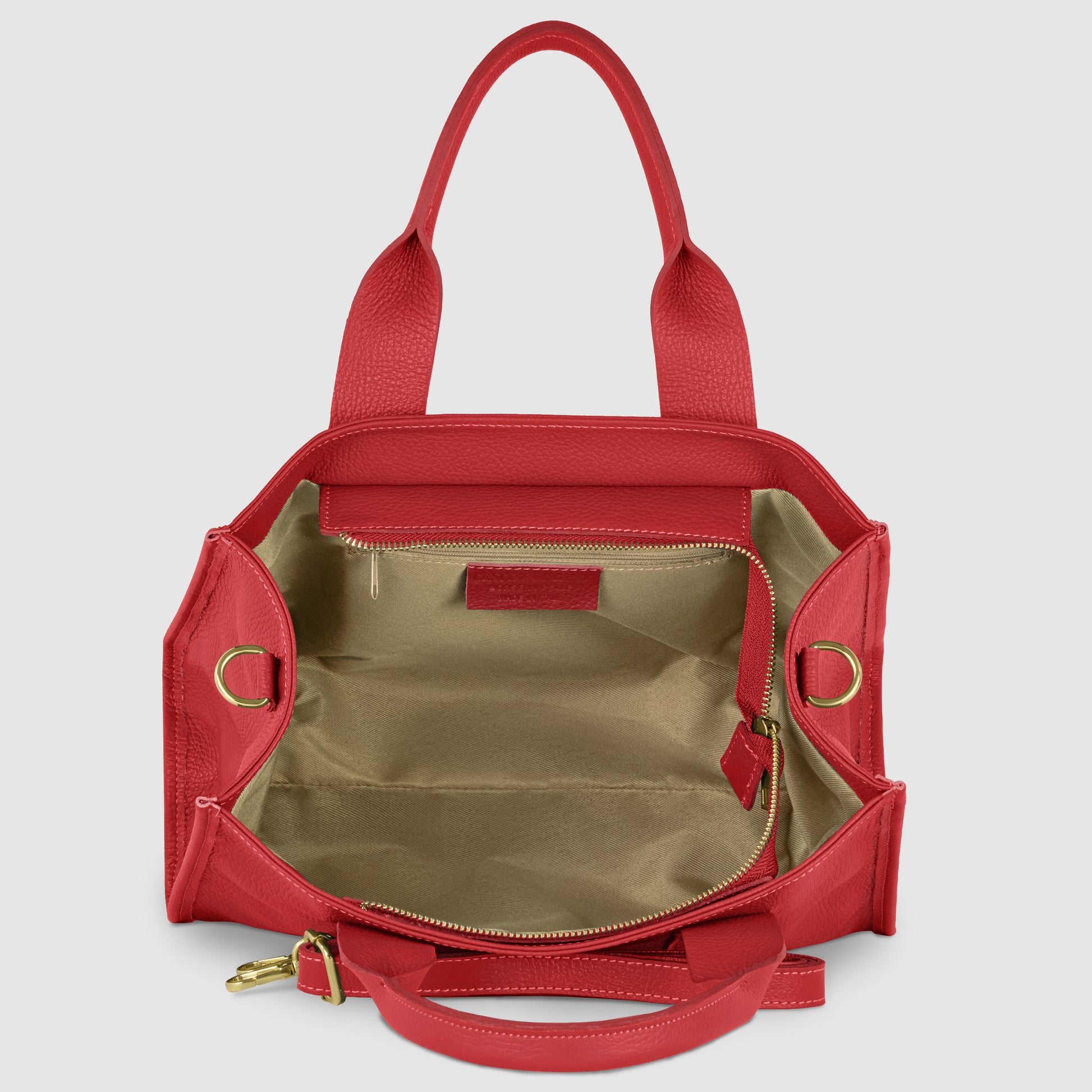Open red Italian leather handbag with beige fabric interior, gold zipper pocket, and gold hardware. This structured leather bag features two handles and an adjustable shoulder strap, displayed against a plain light background.