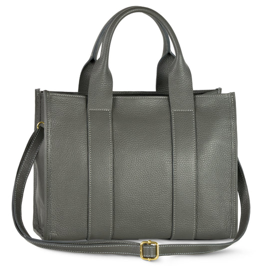 A structured designer bag in gray Italian leather features two short handles and a long adjustable shoulder strap with a gold buckle, shown against a white background.