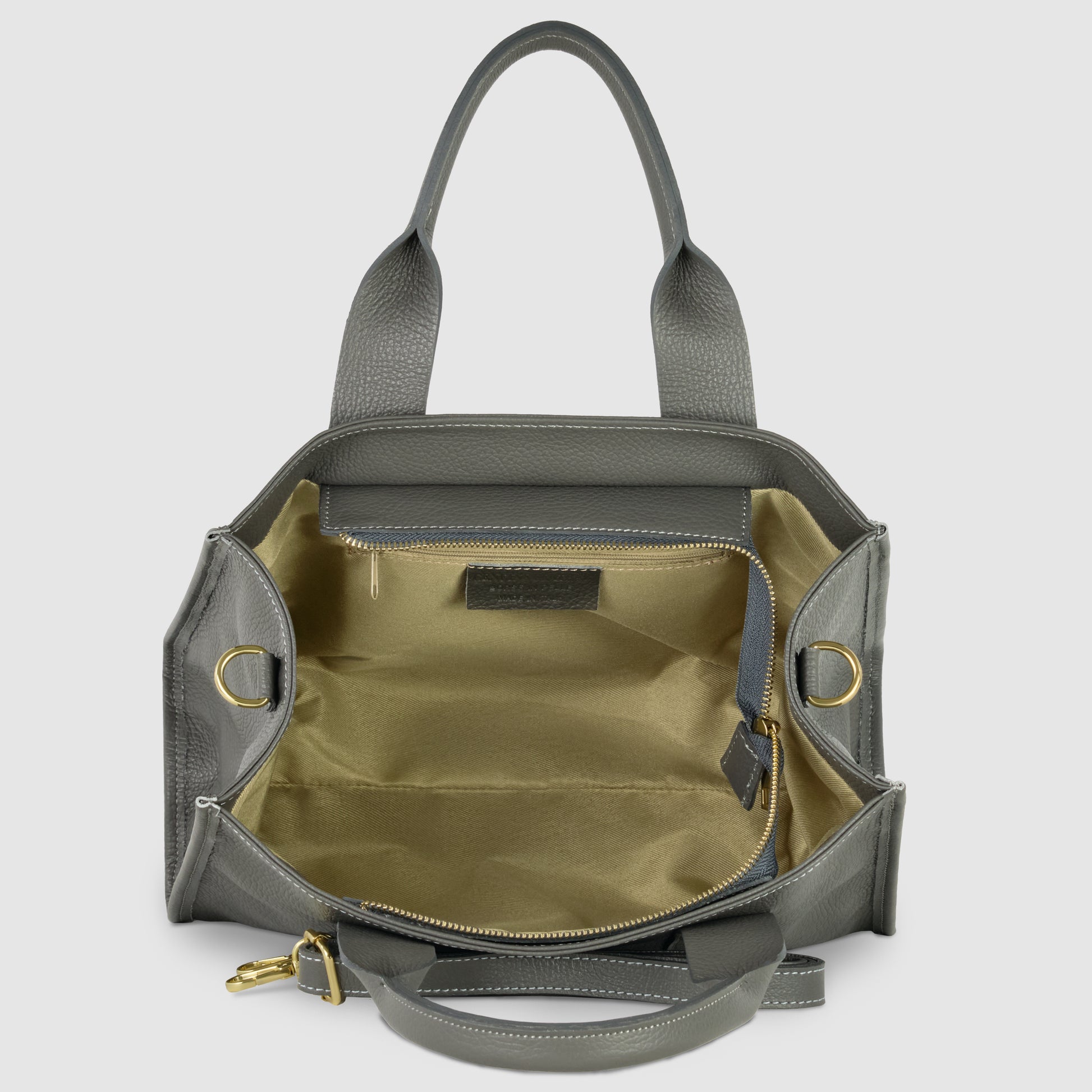 A grey Italian leather handbag with gold hardware is shown open, revealing a spacious beige interior, a zippered pocket, and an adjustable shoulder strap attached to the sides.