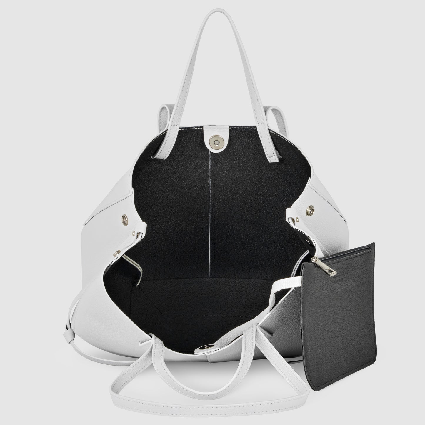 A white Italian leather handbag with two handles, open to reveal a spacious black interior and a detachable black zippered pouch attached inside. This convertible tote is both stylish and practical.