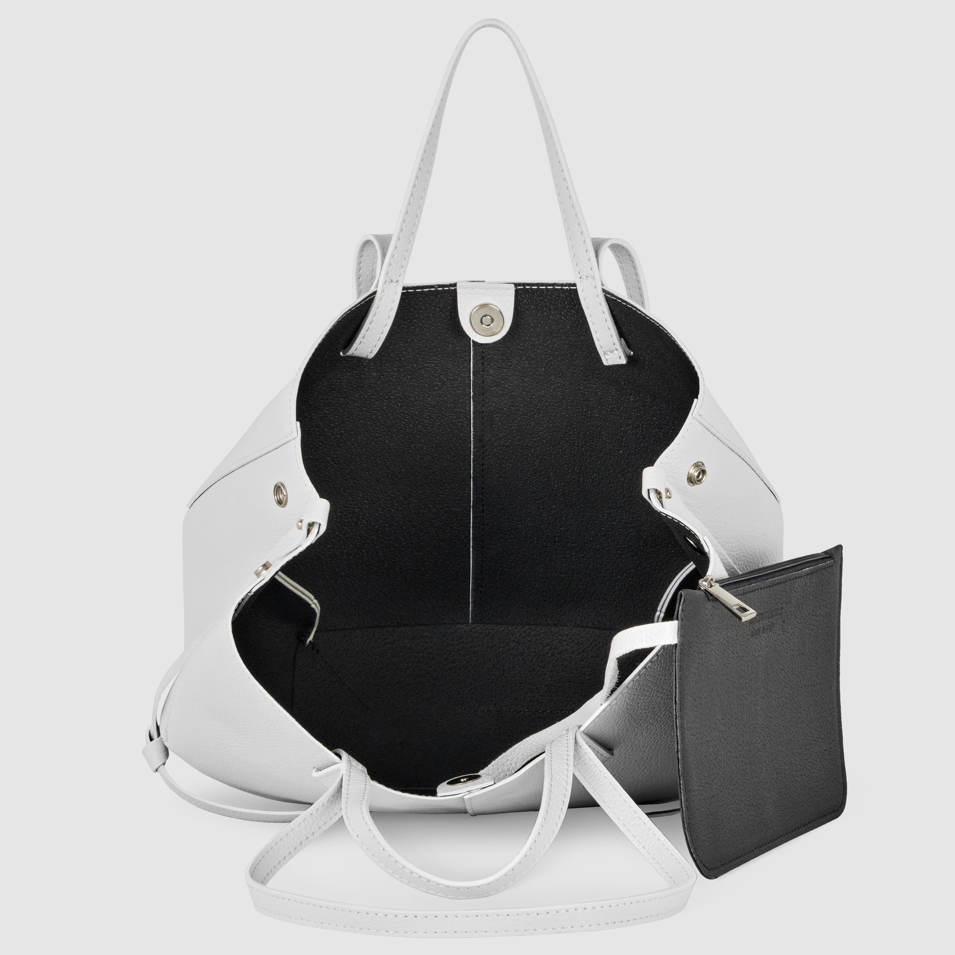 A white Italian leather handbag with two handles, open to reveal a spacious black interior and a detachable black zippered pouch attached inside. This convertible tote is both stylish and practical.