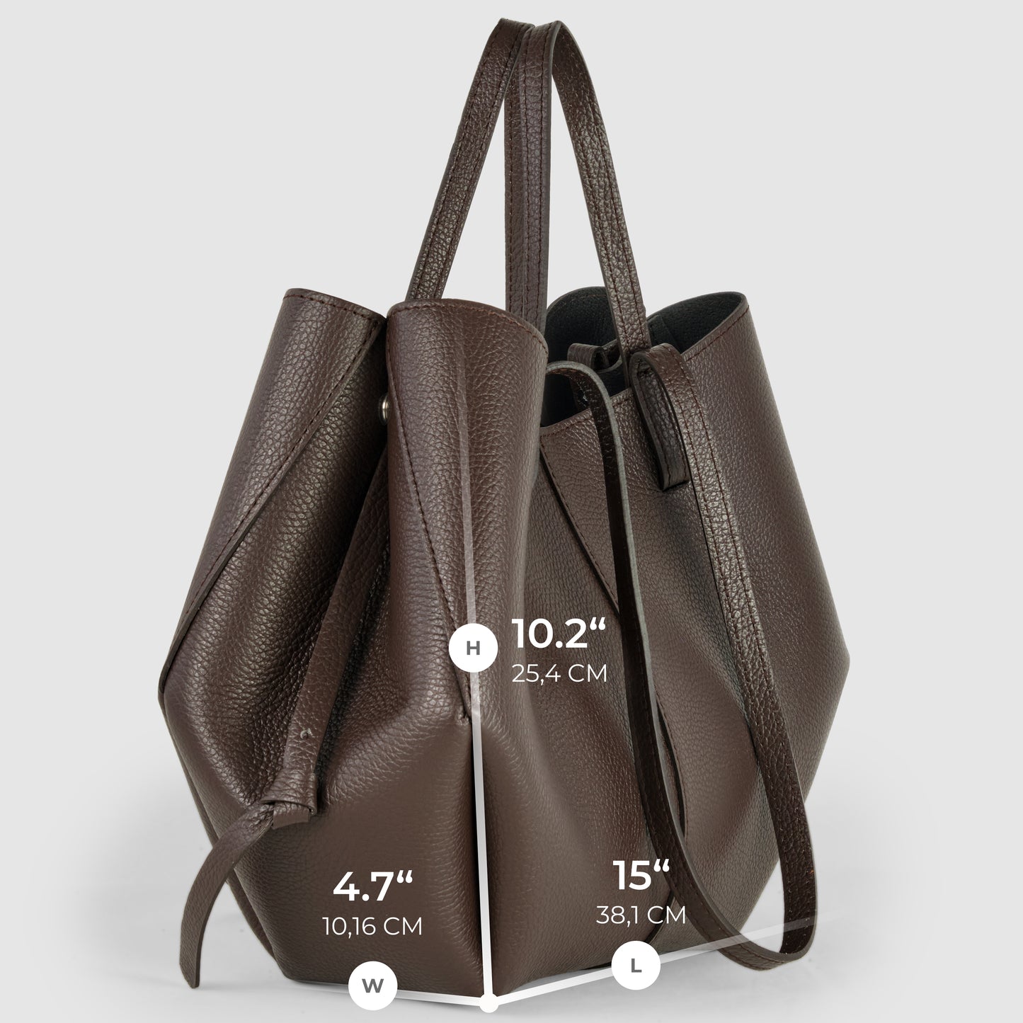 A brown Italian leather handbag stands upright, displaying its dimensions: 10.2 inches high, 4.7 inches wide, and 15 inches long. This convertible tote features two long handles and a slightly textured surface.