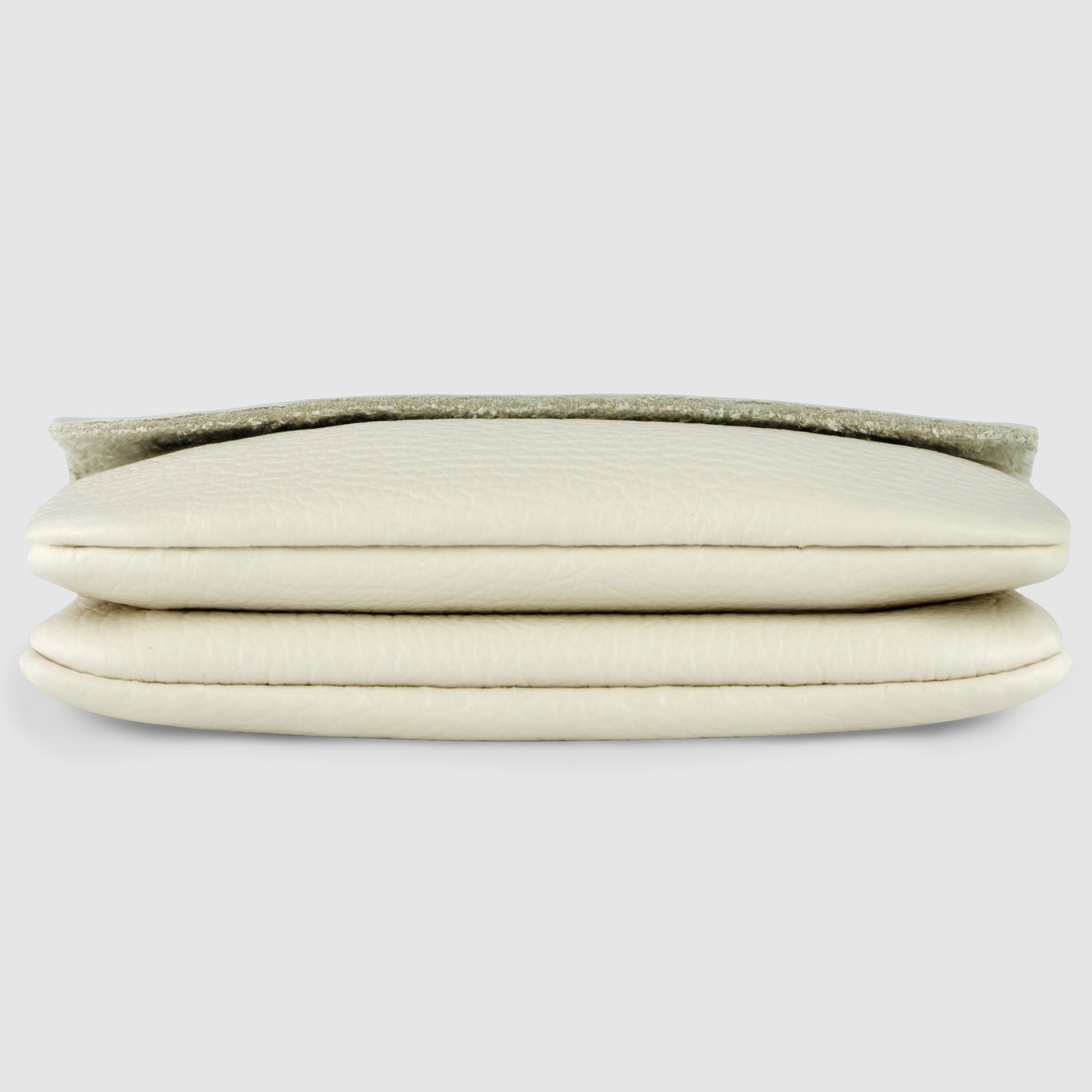 A close-up view of a folded, cream-colored Italian leather wallet with a textured surface, shown from the side on a plain light gray background.