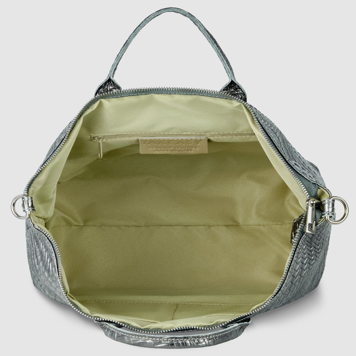 Open metallic suede bag in silver with a light beige interior, featuring a zippered pocket and open main compartment. This handbag has a top handle and silver hardware on the sides.