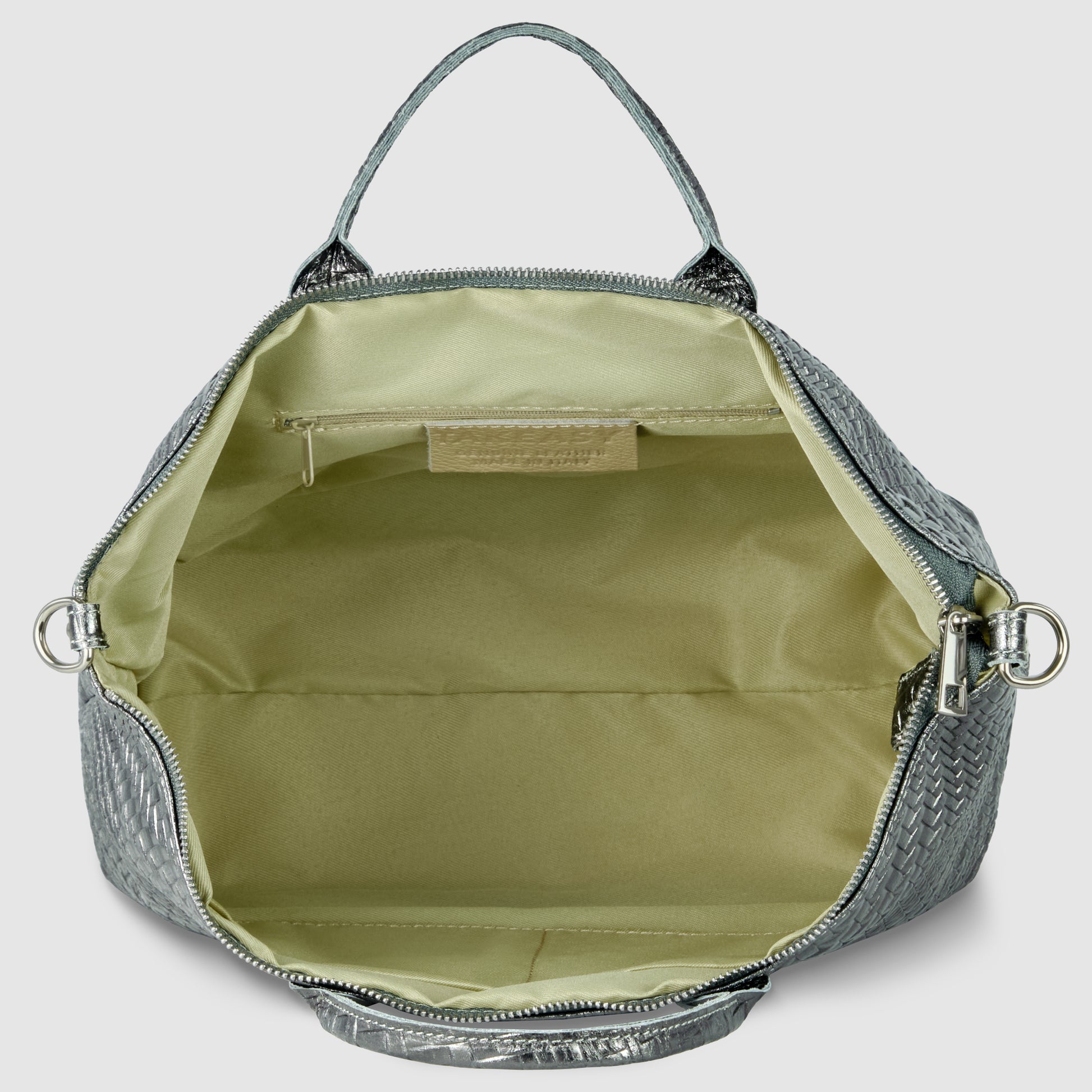 Open metallic suede bag in silver with a light beige interior, featuring a zippered pocket and open main compartment. This handbag has a top handle and silver hardware on the sides.