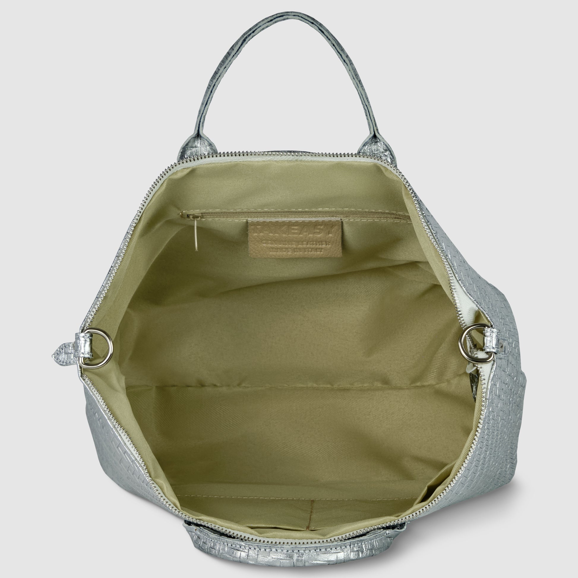 Open metallic suede bag with beige interior, featuring one zipped pocket and a rectangular leather patch on the inside lining. This Italian leather handbag has two handles and is empty.