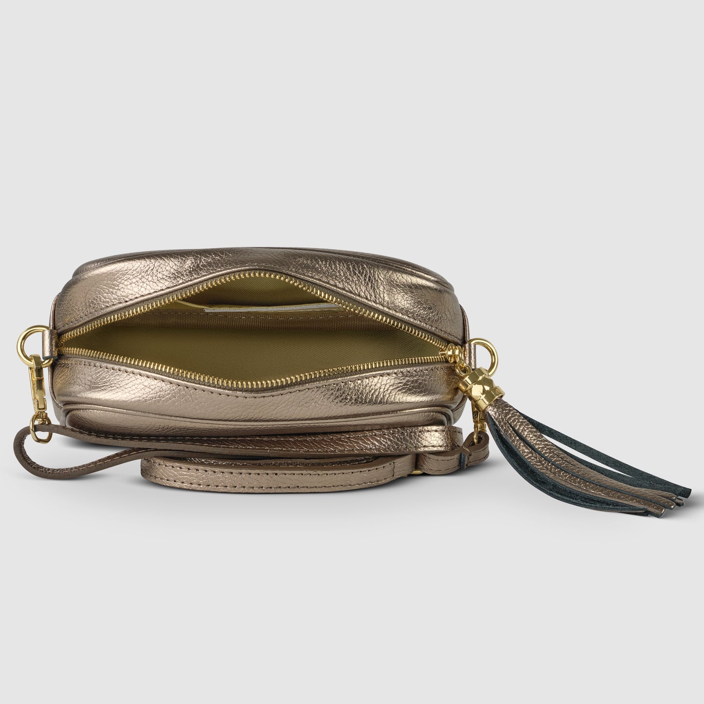 A metallic gold crossbody handbag with a zipper partially open, revealing the interior. Crafted from luster calfskin, the bag features a long strap, gold hardware, and a decorative black and gold tassel on the zipper pull.