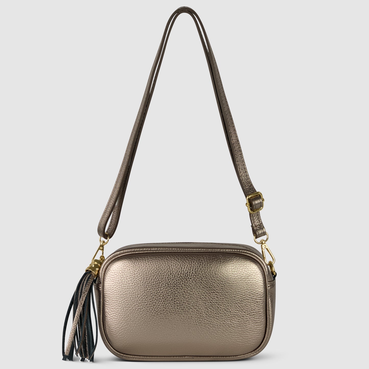 Metallic gold crossbody handbag with an adjustable strap, gold hardware, and a decorative black and gold tassel attached to one side, crafted from luster calfskin and displayed on a plain light background.