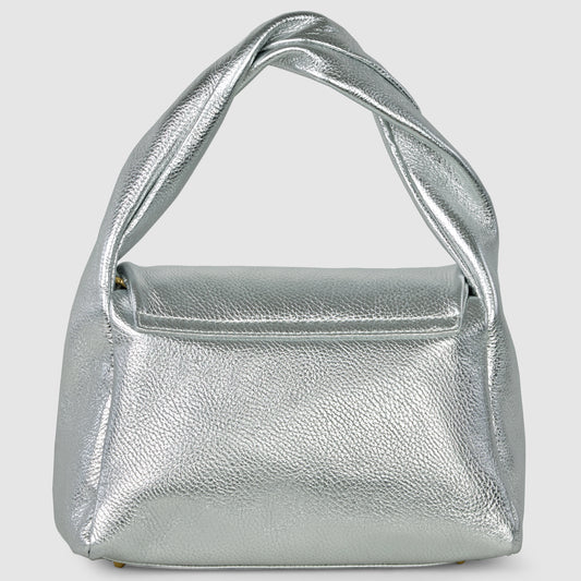 A metallic silver Italian leather bag with a textured surface, structured rectangular body, and wide twisted top handle, handcrafted from calf leather and set against a plain light grey background.
