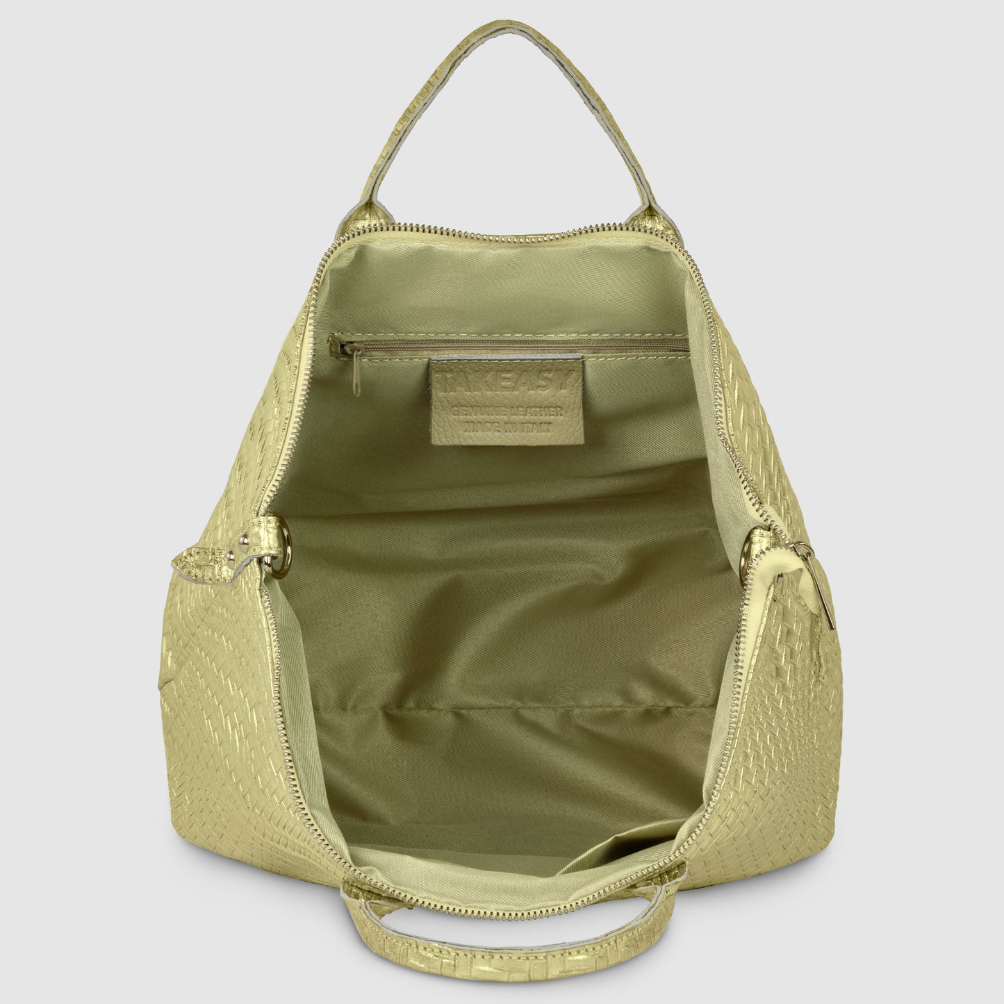 Open light green Italian leather handbag with a textured exterior, shown from above. The interior is empty with a zippered pocket and visible label on the back wall. This handcrafted women's bag features a top handle and zipper closure.