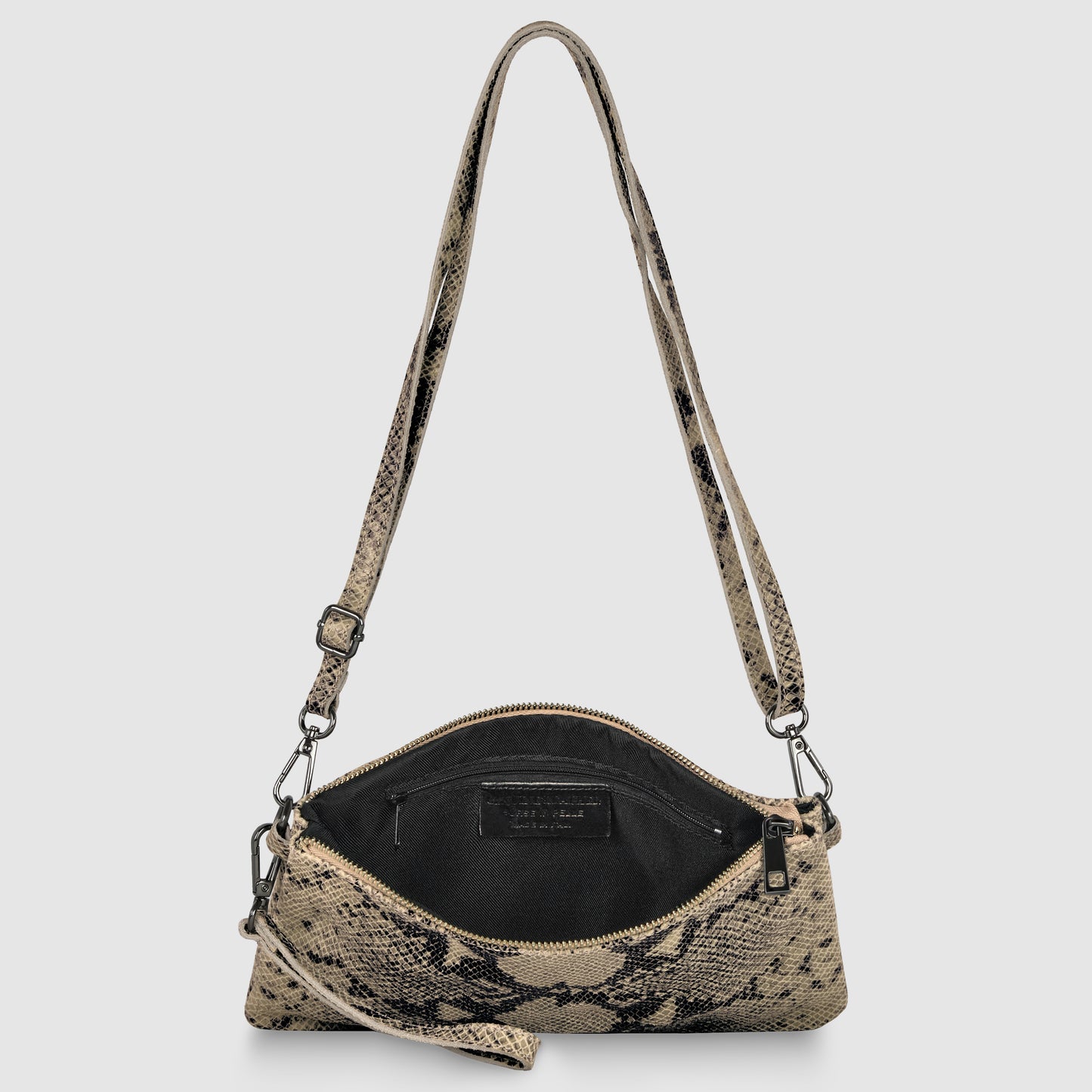 A small, rectangular crossbody wristlet featuring a beige and black snakeskin pattern, black zipper, and adjustable strap. The bag is open, revealing a black interior with a visible label inside.