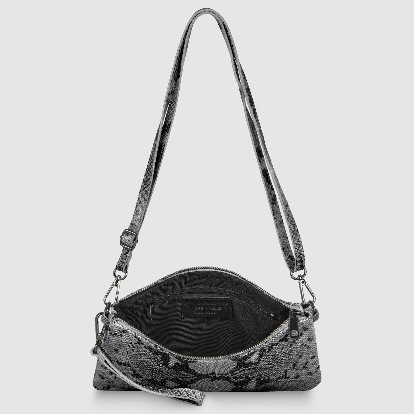 A small Italian handcrafted bag with a gray and black snakeskin pattern, shown open to reveal a black interior with a visible label. The crossbody wristlet features a zip closure, an adjustable strap, and silver-toned hardware.