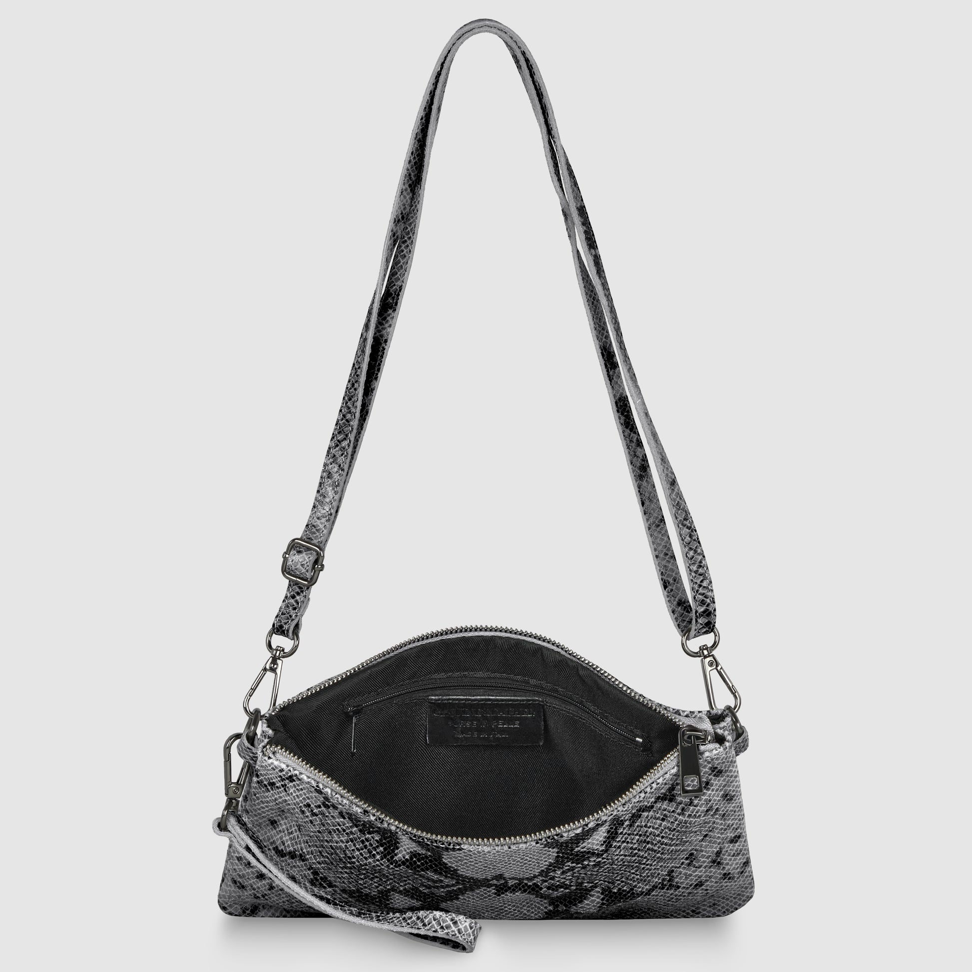 A small Italian handcrafted bag with a gray and black snakeskin pattern, shown open to reveal a black interior with a visible label. The crossbody wristlet features a zip closure, an adjustable strap, and silver-toned hardware.