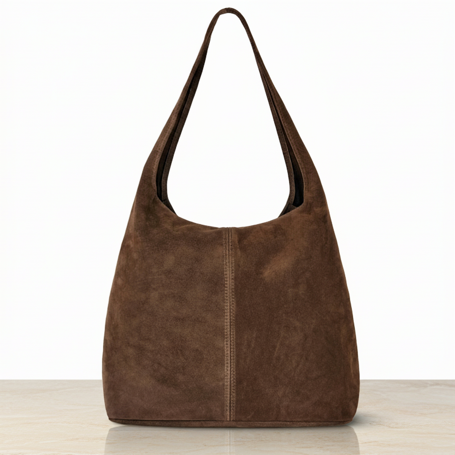 A minimalist suede handbag in rich brown, featuring a single wide strap, displayed upright on a light-colored surface—a timeless nod to Florentine craftsmanship against a plain white background.