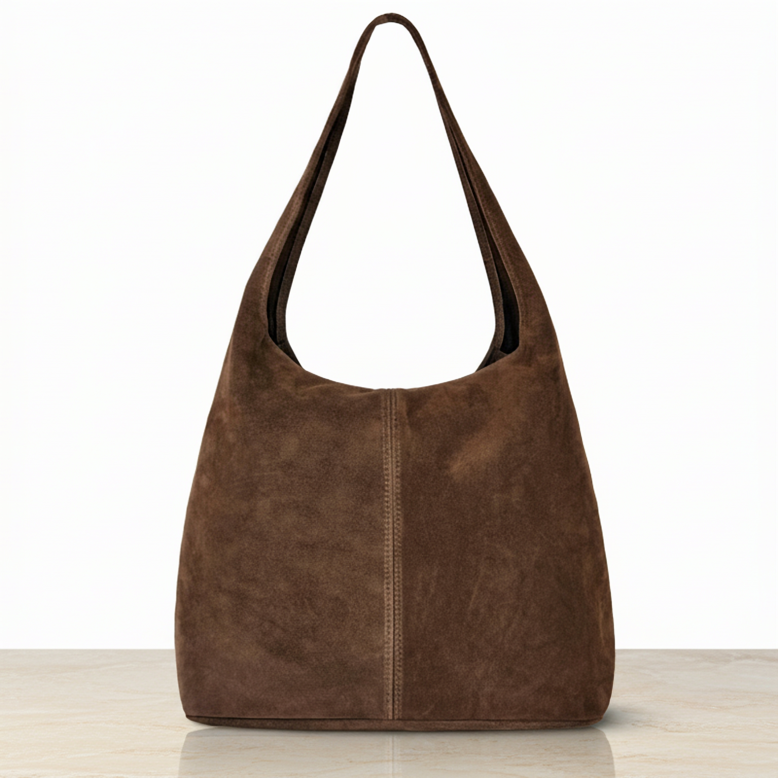 A minimalist suede handbag in rich brown, featuring a single wide strap, displayed upright on a light-colored surface—a timeless nod to Florentine craftsmanship against a plain white background.