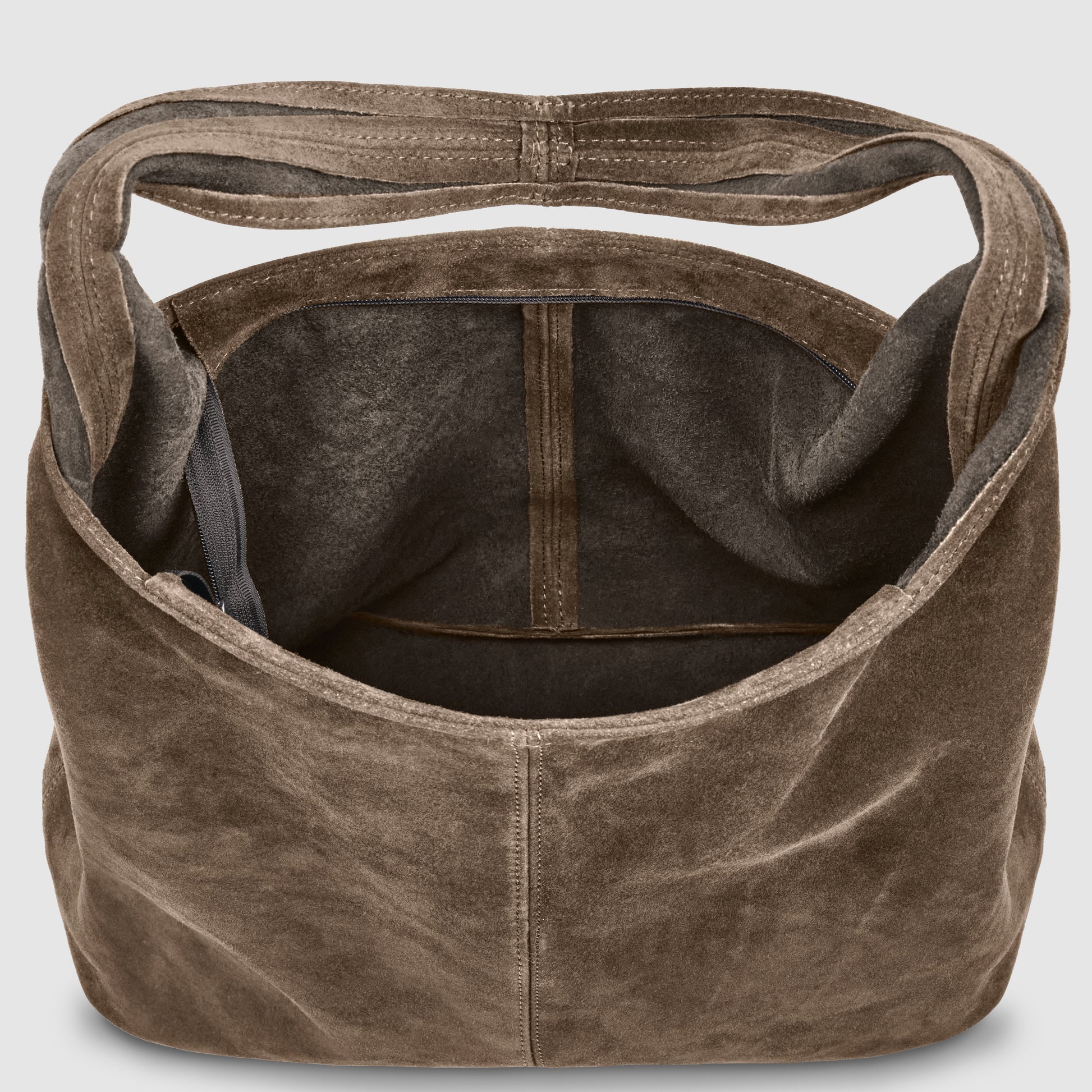 A large, open, minimalist shoulder bag crafted from brown Italian suede, with a wide strap and visible inner pocket—shown from above to highlight its spacious interior and soft texture.