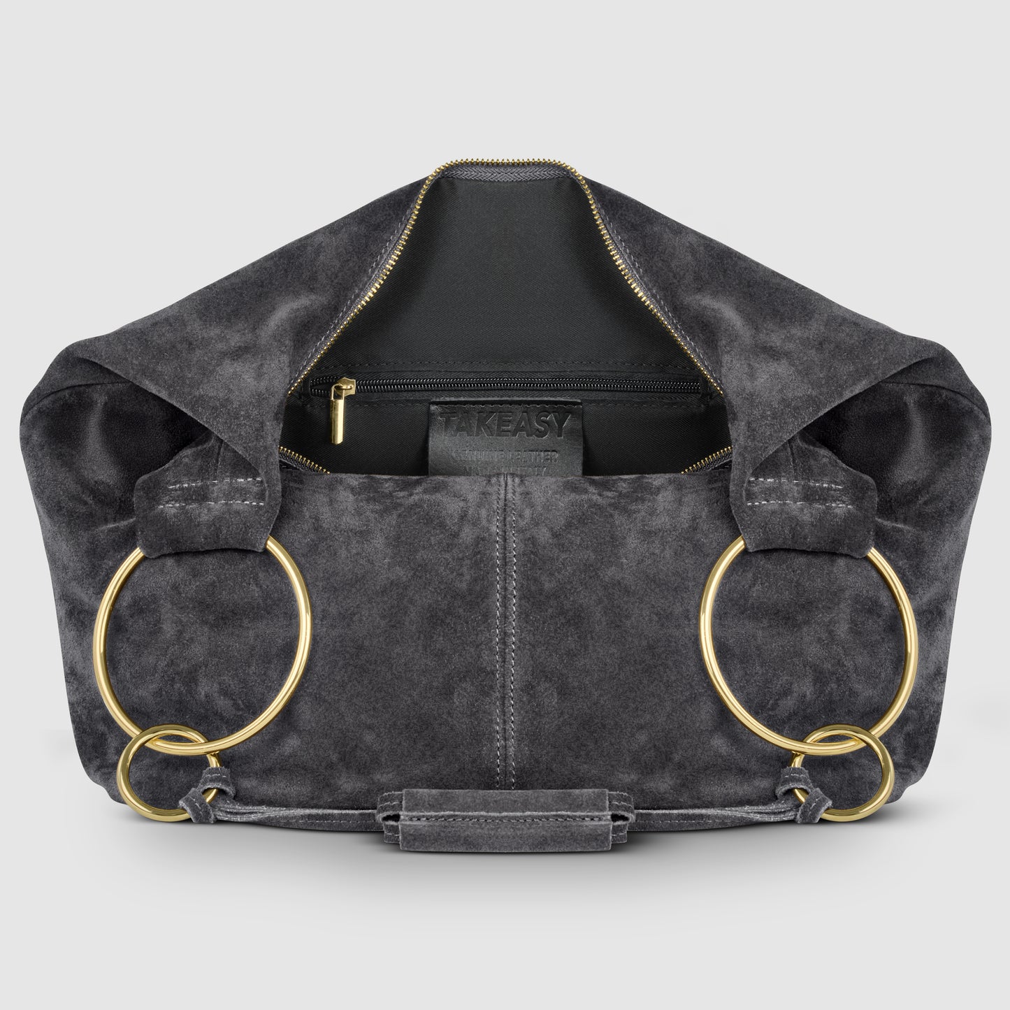 A dark gray natural suede bag with a gold zipper, large gold rings as handles, and an interior pocket displaying the brand TAKEASY. The bag is open, revealing its spacious inside.