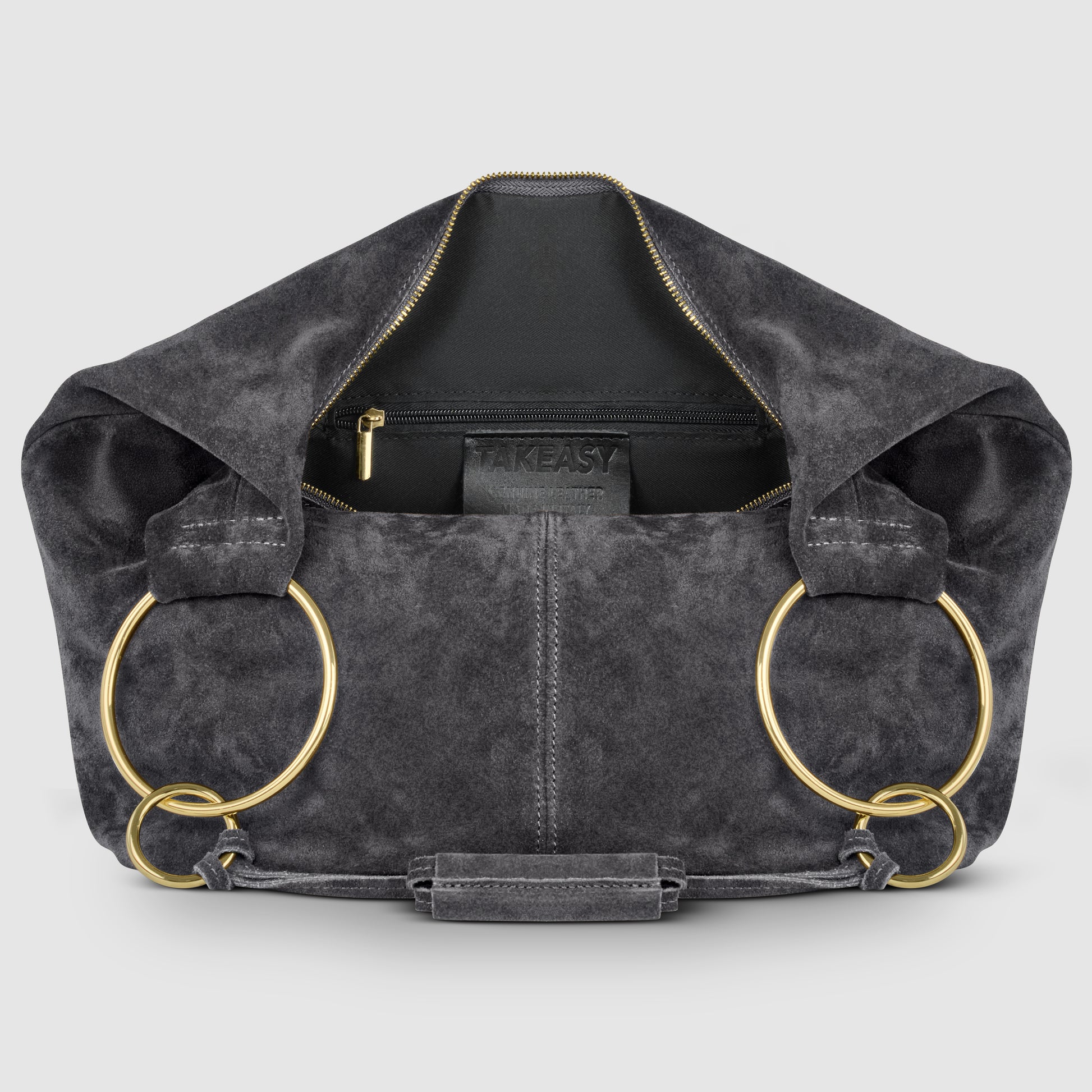 A dark gray natural suede bag with a gold zipper, large gold rings as handles, and an interior pocket displaying the brand TAKEASY. The bag is open, revealing its spacious inside.