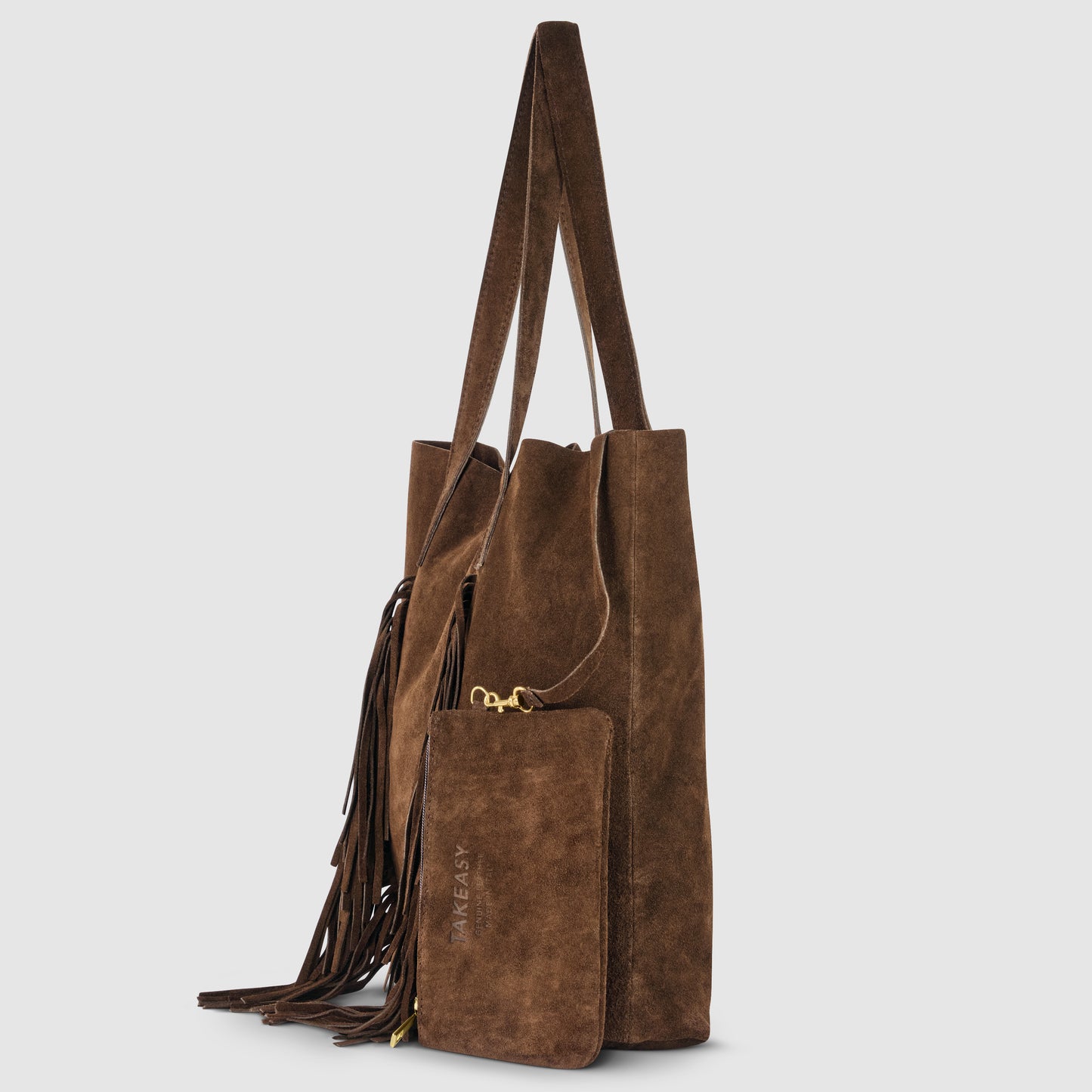 A brown suede handbag with long handles, fringe detailing on one side, and a matching suede zip pouch attached by a gold clasp. The pouch is embossed with TAKE IT EASY for a true bohemian handbag vibe.