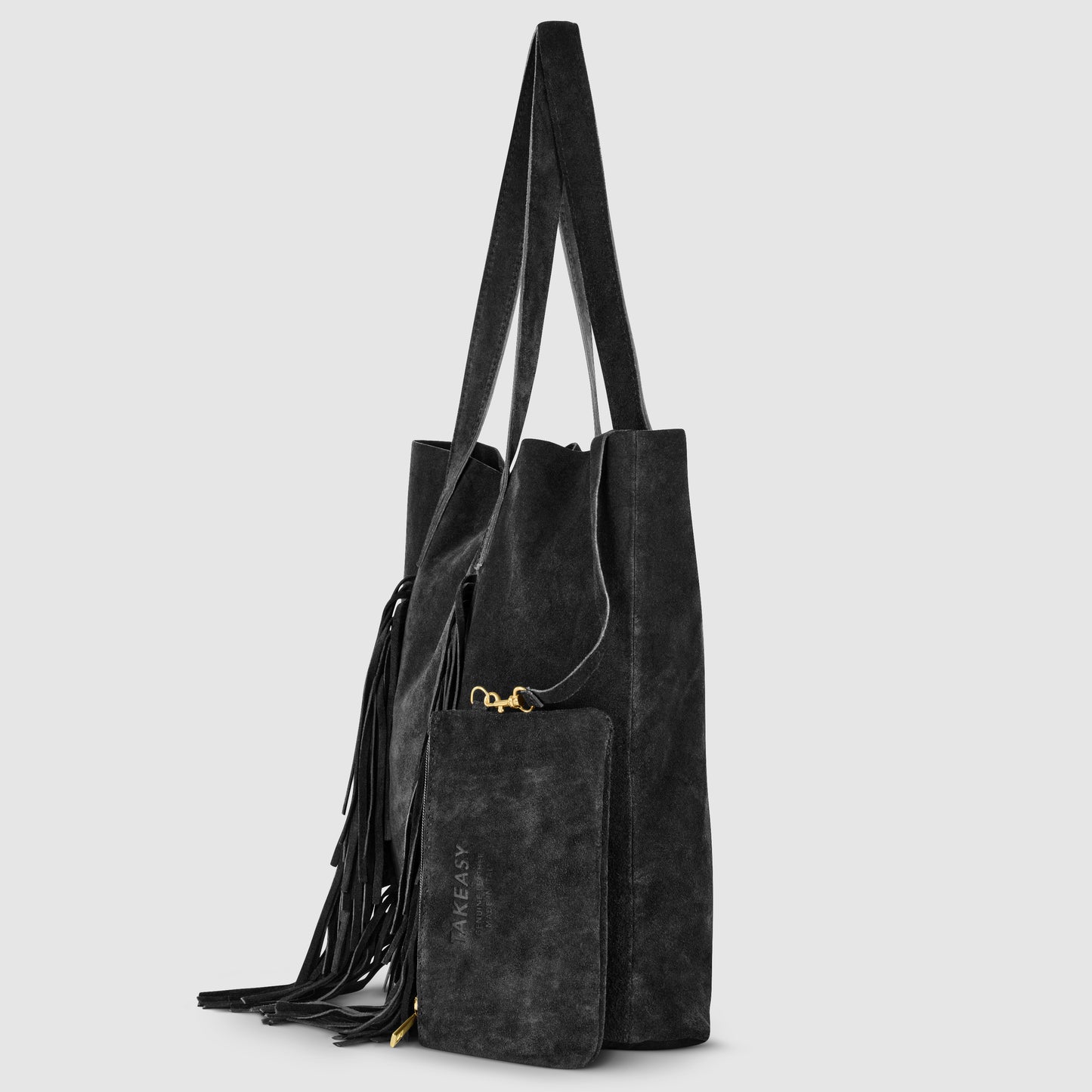 Black suede handbag with long straps, side fringe detailing, and a matching zippered pouch attached. This Italian handcrafted bag features gold hardware and TAKE EASY embossed on the front. Set against a light gray background.
