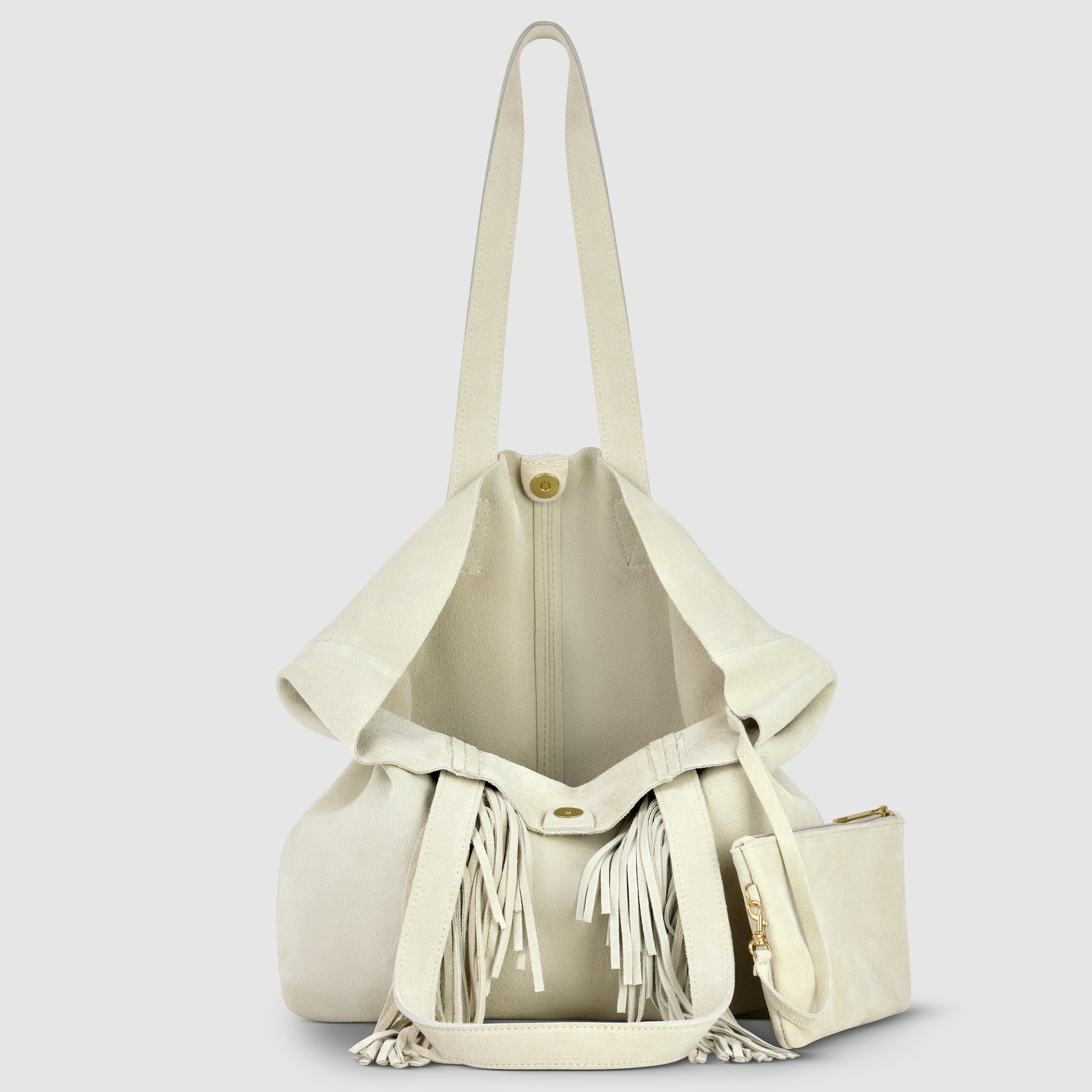 A cream-colored suede handbag with a long shoulder strap, drawstring closure featuring tassels, and a matching zippered pouch in front. The bag is open, displaying its spacious interior—perfect for those who love a bohemian handbag style.