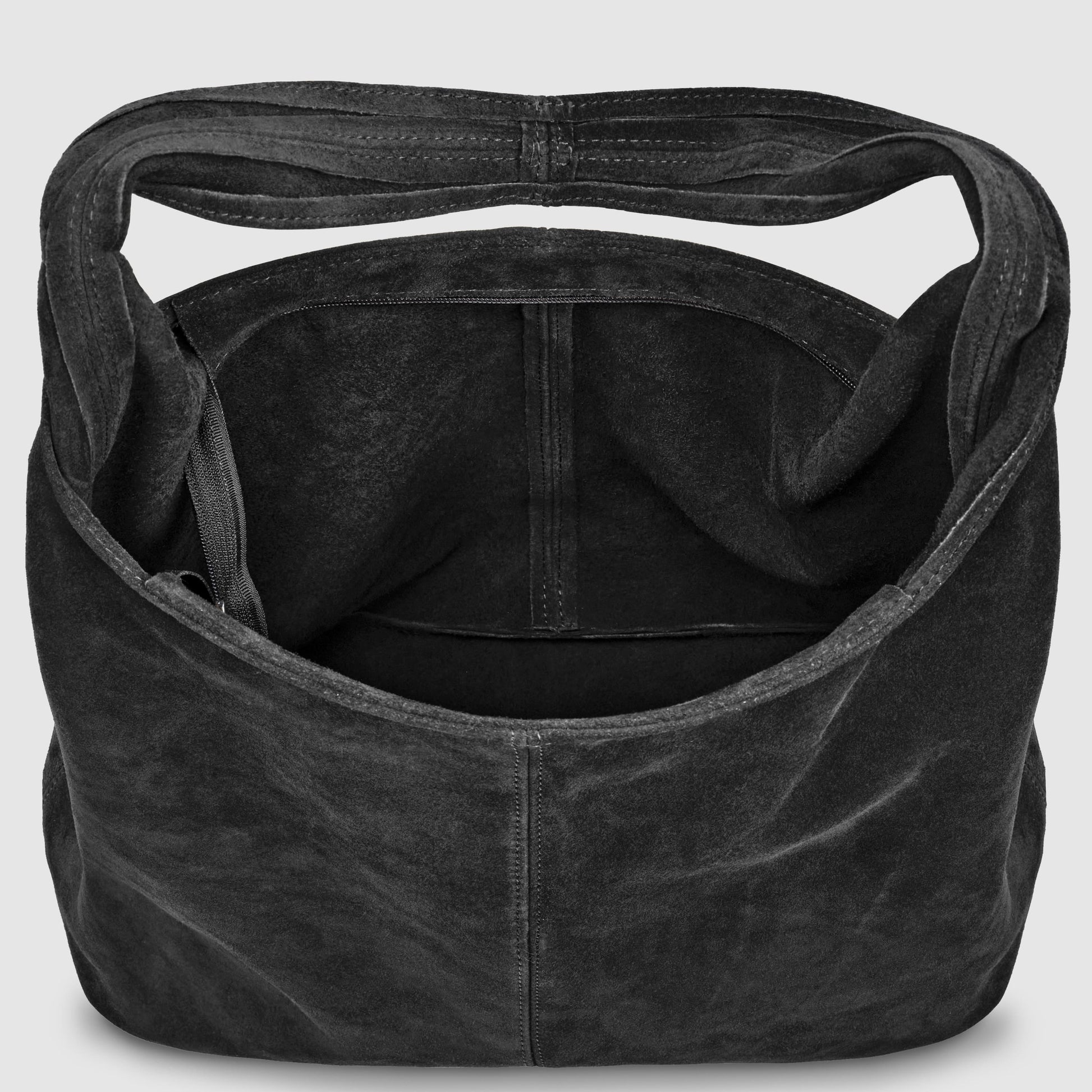 A large, open-top slouchy suede shoulder purse with a single wide strap and visible inner pocket sits against a plain light background. The inside of this spacious natural suede handbag is roomy and unlined.