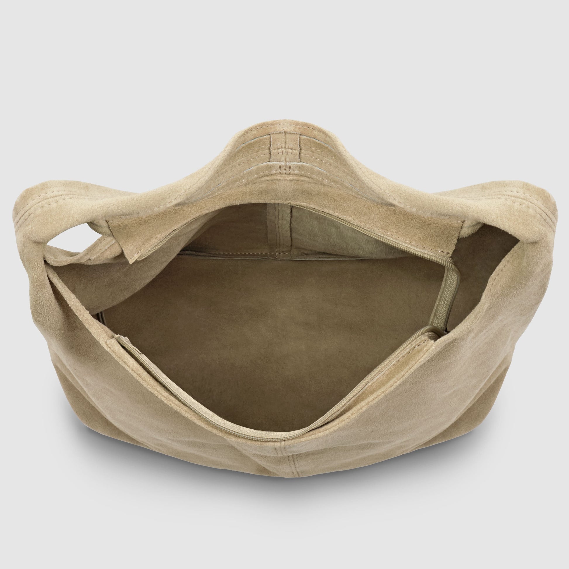 Beige slouchy suede shoulder purse viewed from above, showing an empty main compartment and an interior zippered pocket against a plain white background.