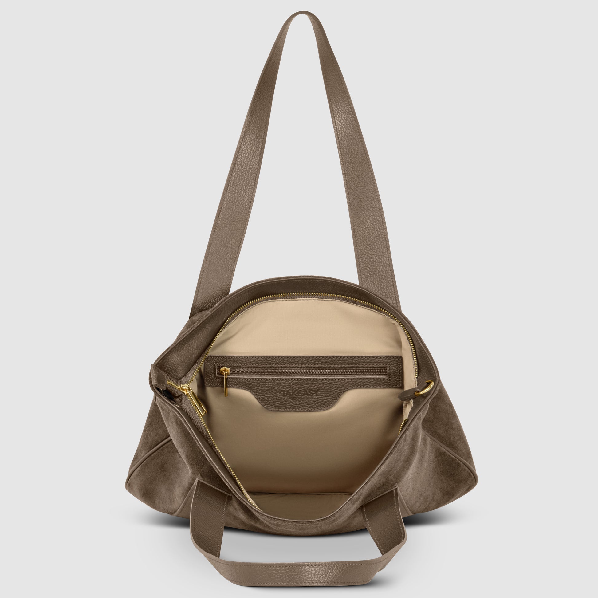 A genuine suede handbag with long handles, shown open to reveal a beige interior lining, a zippered inner pocket, and gold zipper detailing.