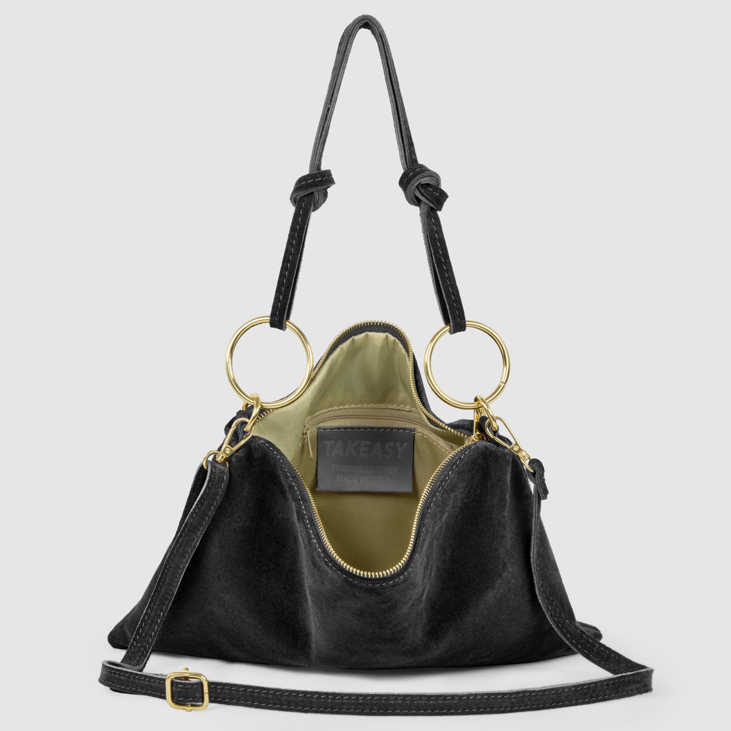 A stylish Italian suede purse with gold ring handles and a detachable shoulder strap, shown open to reveal an olive green interior and a label reading TAKEASY. This slim medium purse rests on a light gray background.