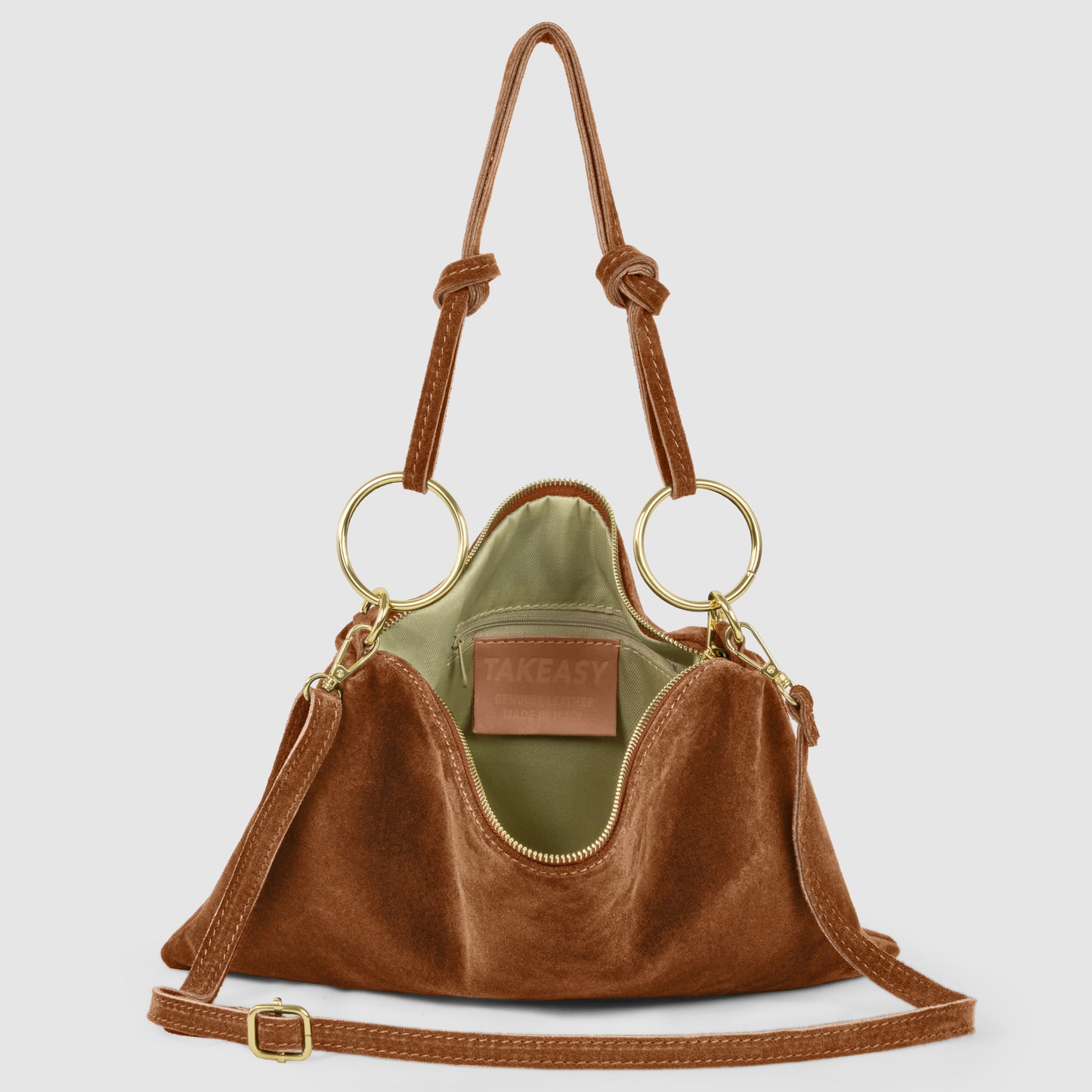 A brown Italian suede purse with gold rings, adjustable shoulder strap, and an open top revealing a green interior and a leather TAKEASY label inside. The real suede leather handbag features knotted handles for added style.