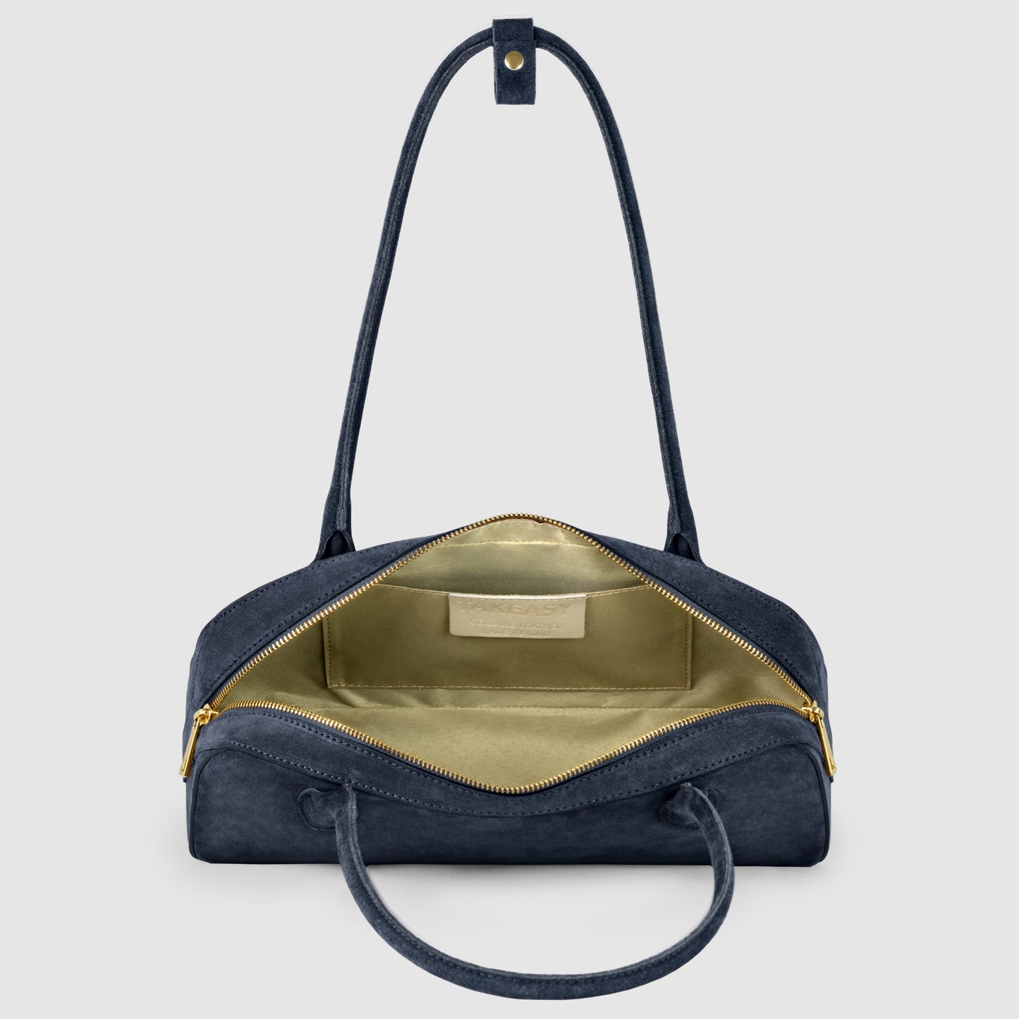 A navy blue Florentine leather handbag with gold zippers is open, showing a spacious light yellow interior and an inner label. The bag has two handles and a detachable strap displayed against a plain light gray background.