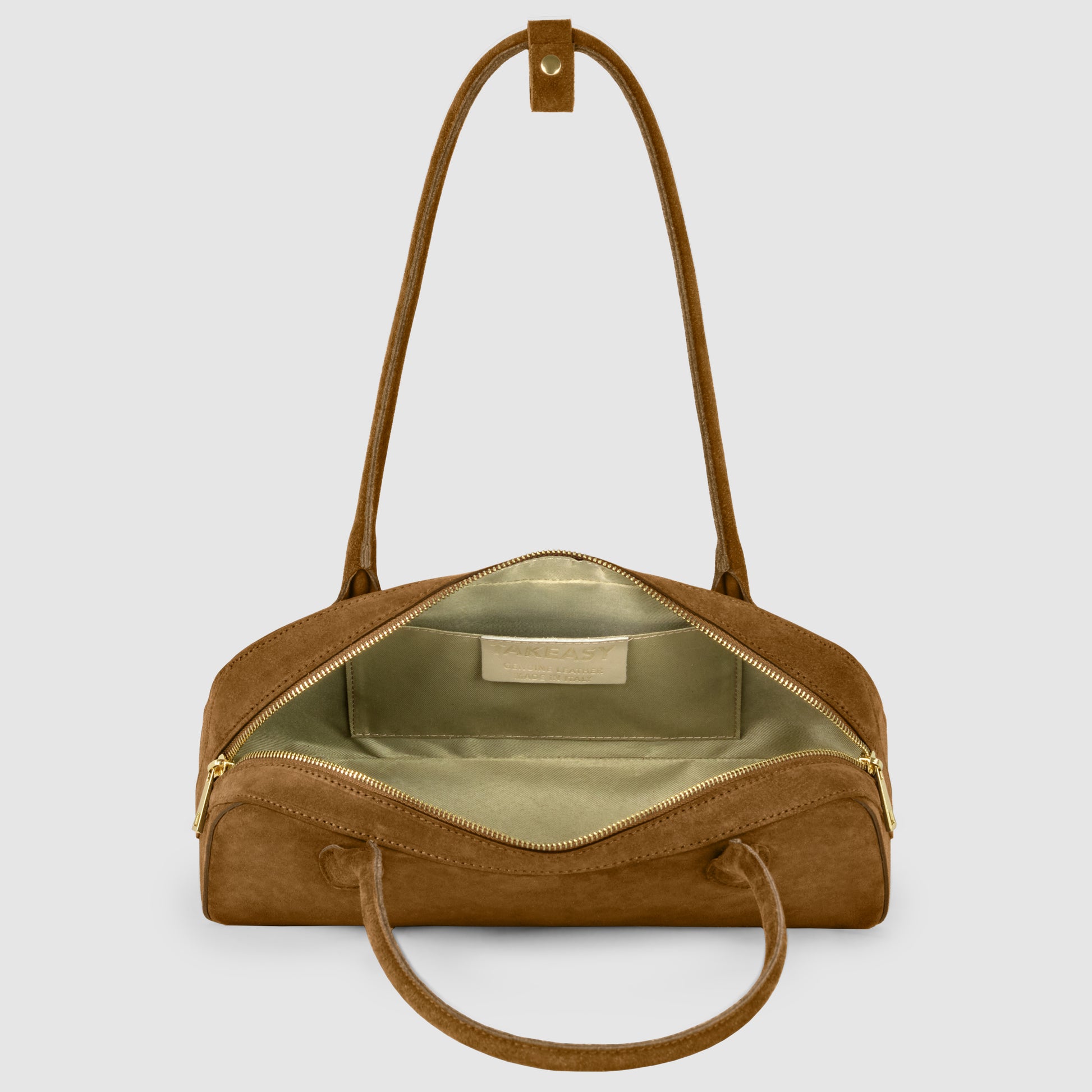 A brown Italian suede leather bag with gold zippers is open to reveal a spacious light green interior and a label on the inner back wall. The bag has both handles and a shoulder strap, shown against a light gray background.