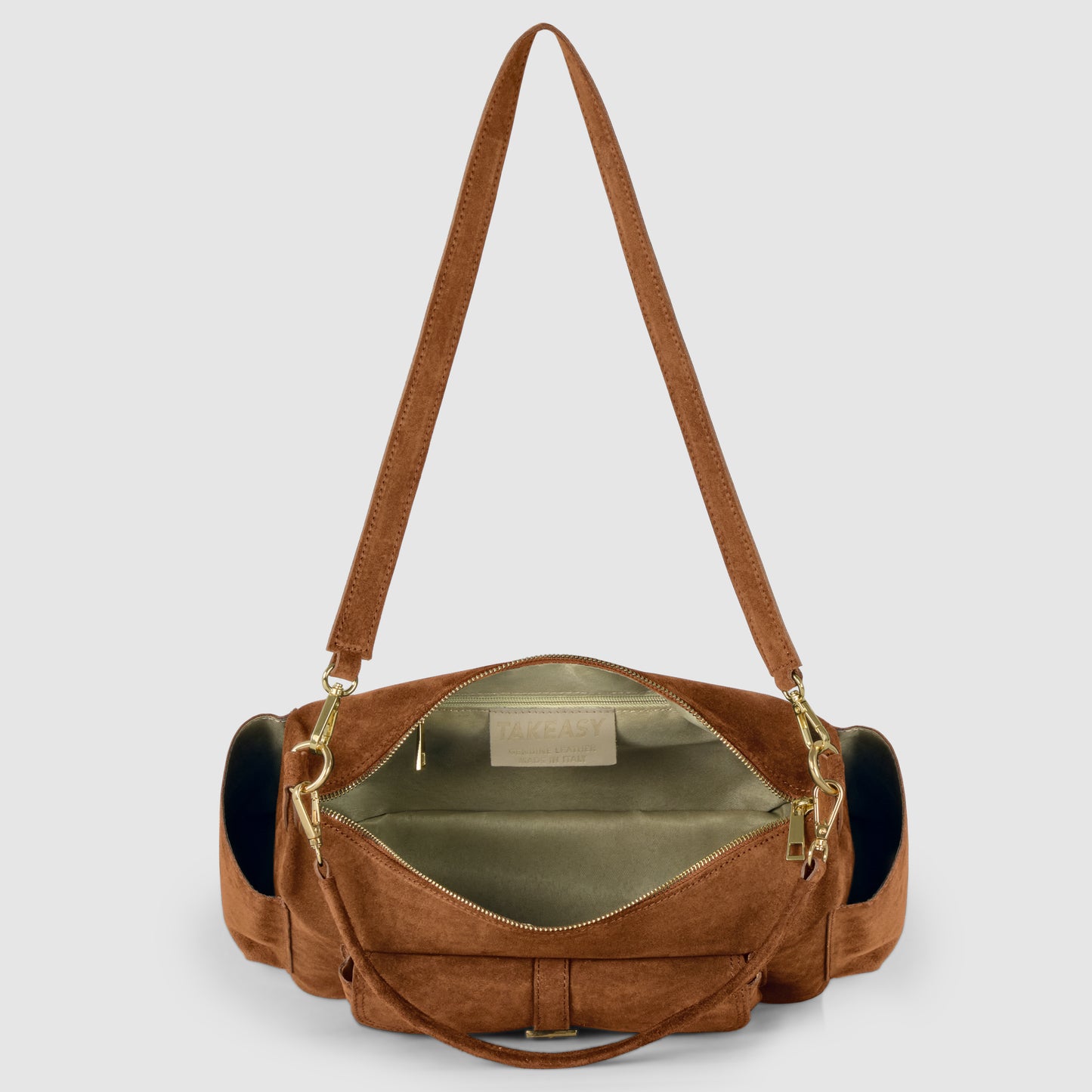 A handmade Italian handbag crafted from genuine suede leather, featuring gold hardware and zippers. Its spacious light beige interior, adjustable strap, and two side pockets highlight expert Florentine leatherworking.