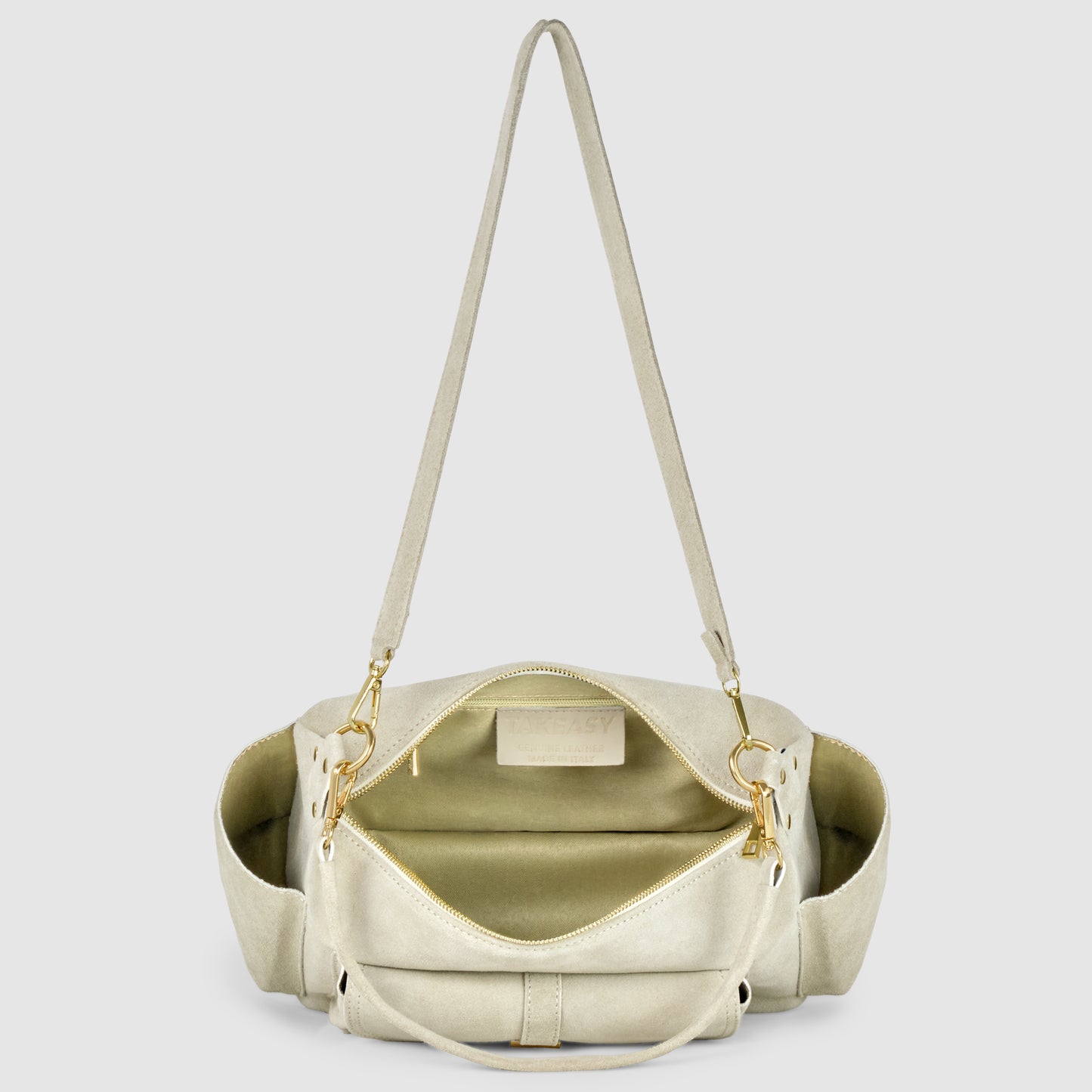 A beige leather shoulder bag, crafted with Florentine leatherworking, is shown open to reveal a spacious, light-colored interior with a zippered pocket. The bag features gold hardware, an adjustable strap, and convenient side pockets.