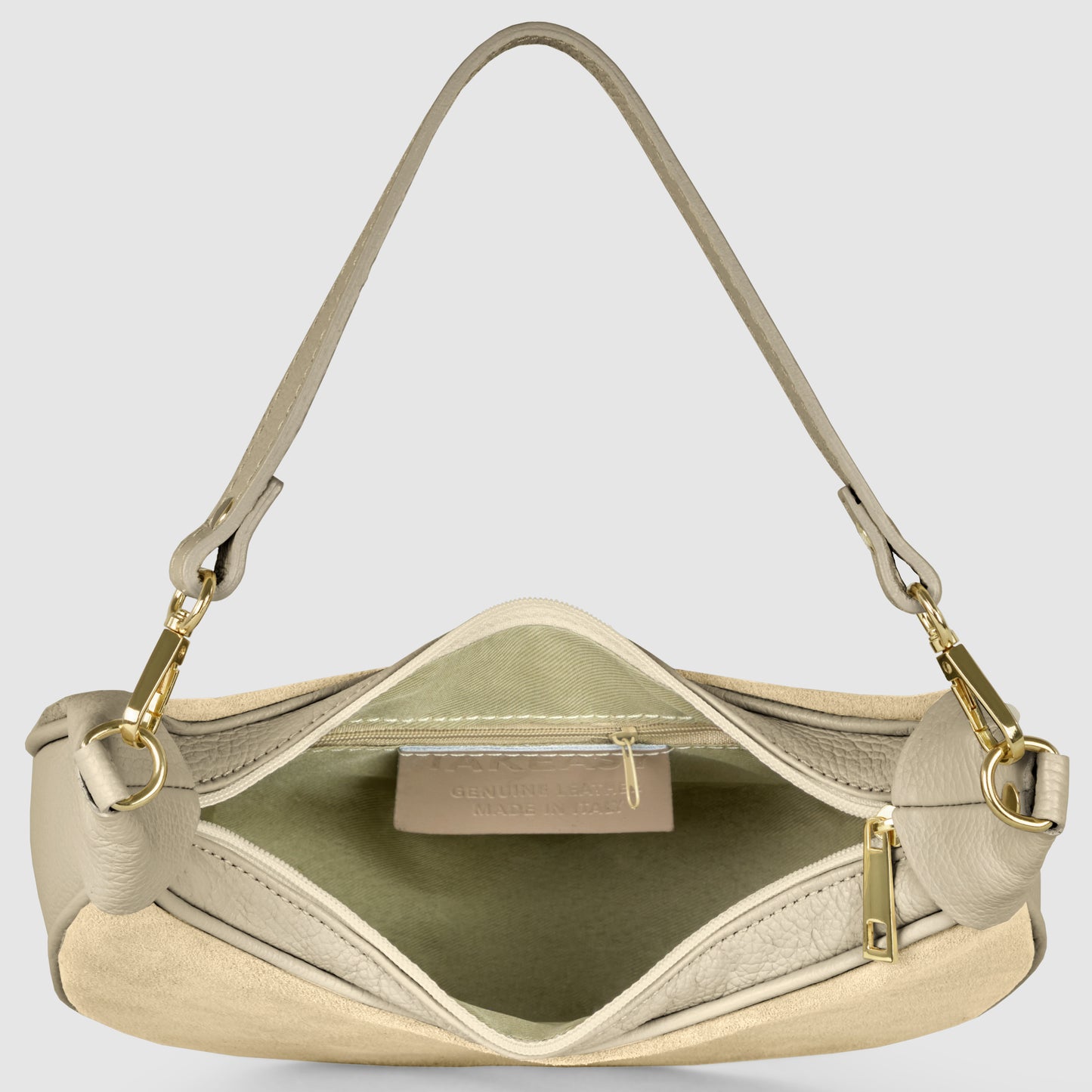 A beige crescent handbag crafted from Italian leather is shown open, revealing a fabric-lined interior with a zippered pocket and visible label. Gold hardware and a single shoulder strap attached with gold clasps complete the elegant design.
