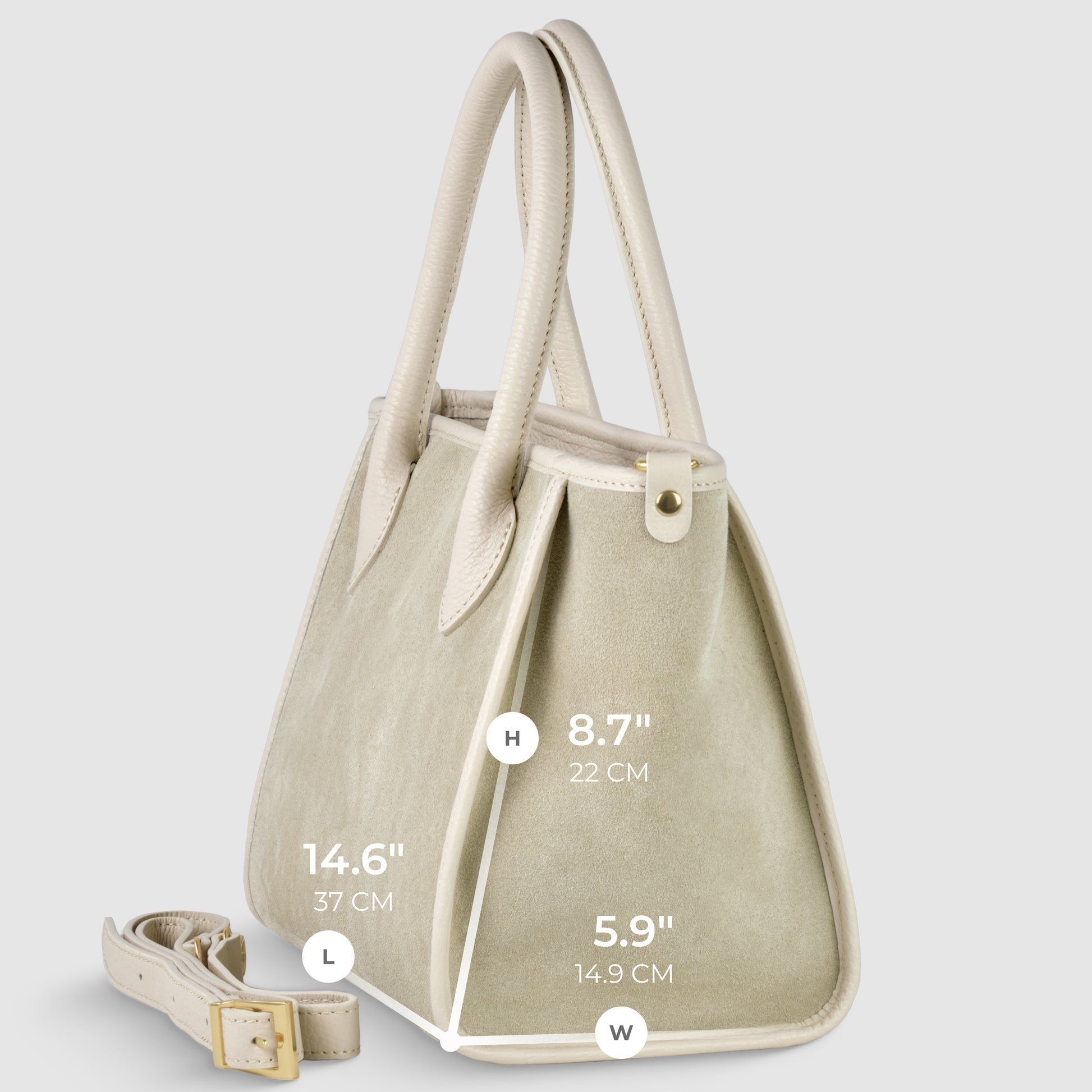 A light beige Italian handcrafted suede leather handbag with off-white handles and trim, shown at an angle. An adjustable strap for crossbody carryall lies beside it. Dimensions: height 8.7 (22 cm), length 14.6 (37 cm), width 5.9 (14.9 cm).